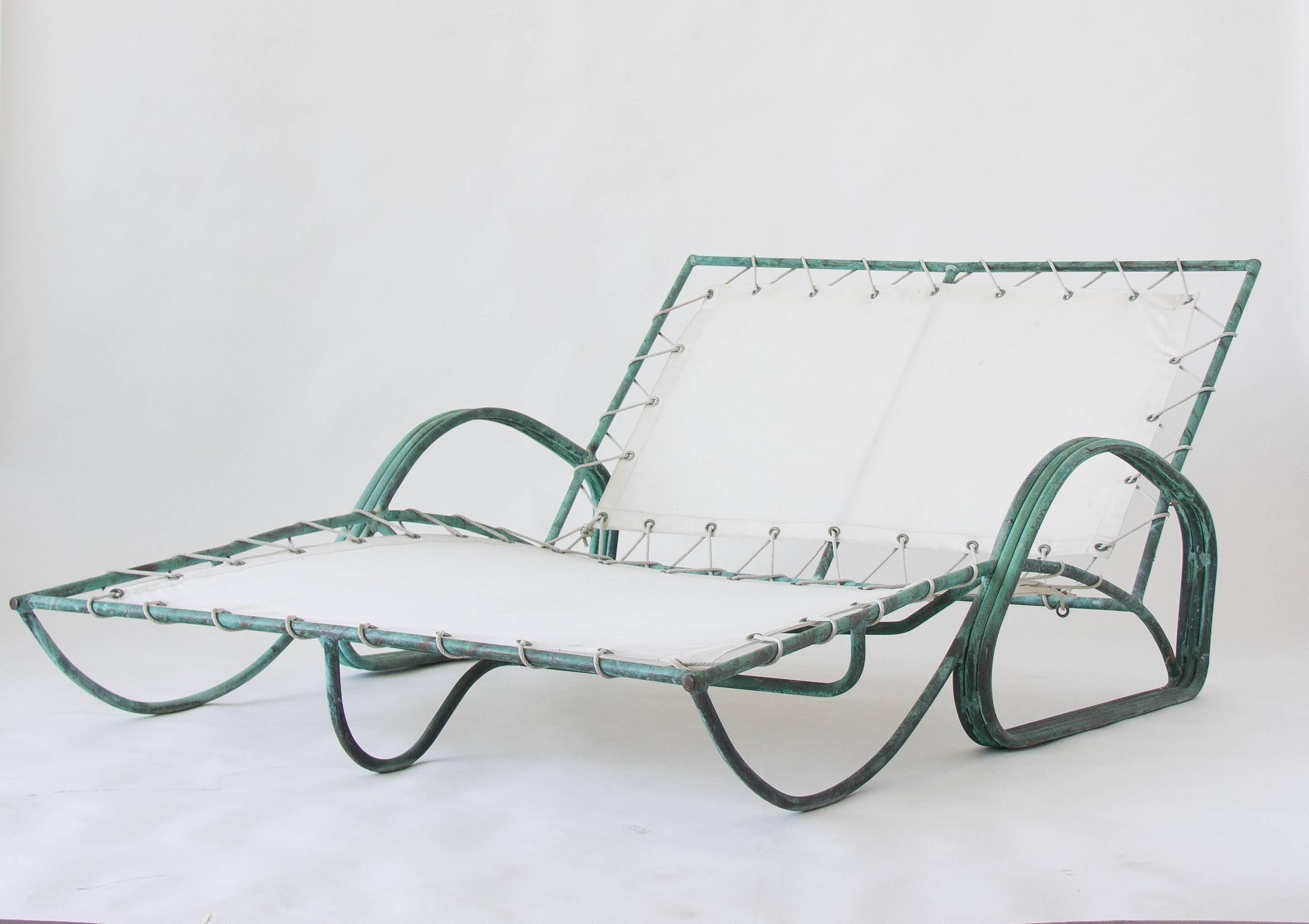 A rare patio chaise longue designed by Walter Lamb and produced by Brown Jordan. The chair has a tubular bronze frame that has oxidized beautifully. A canvas sling is laced to the frame with nylon rope. Three rows of tubular bronze join to form the
