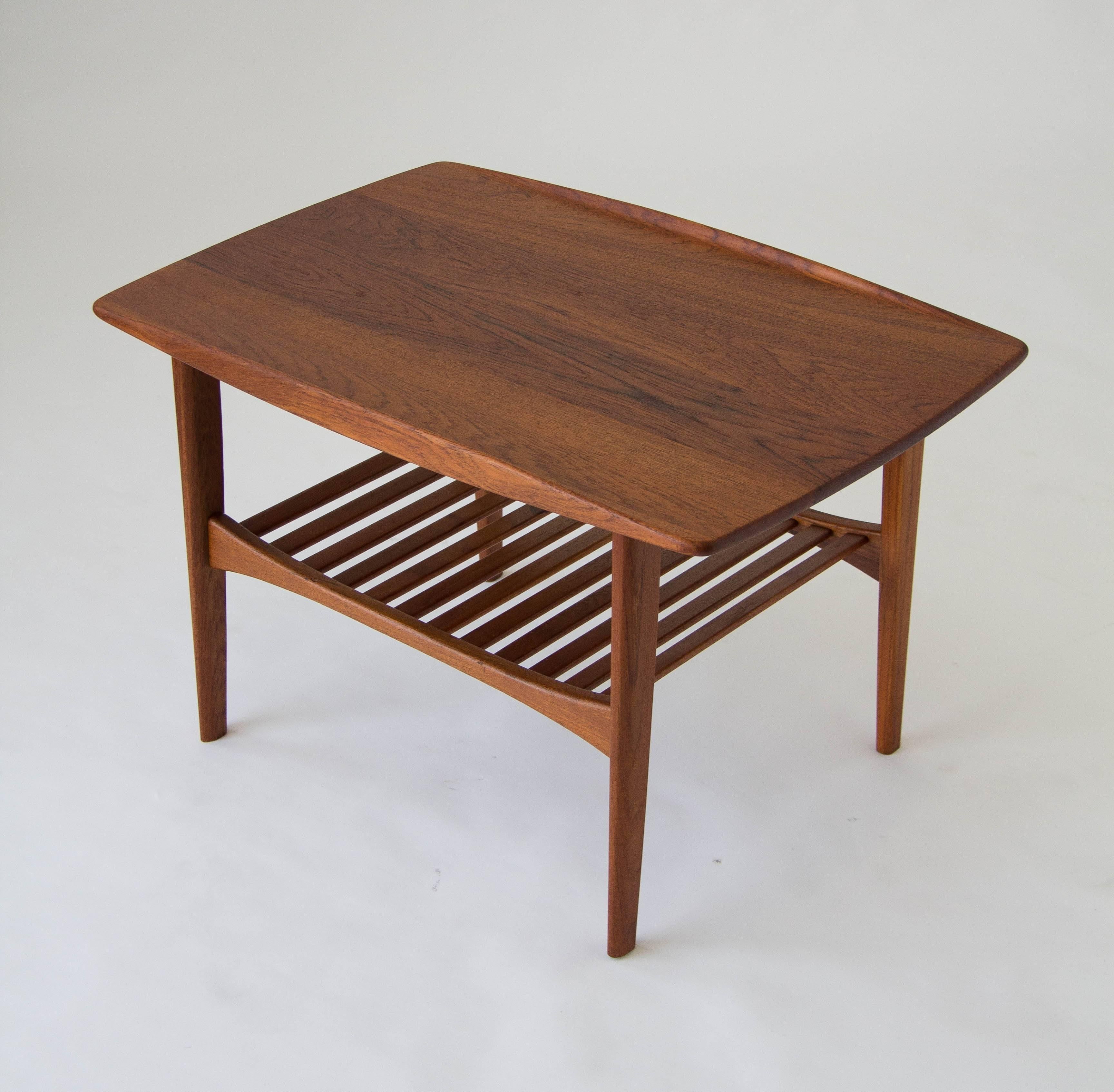 A model FD510 teak side table imported from Denmark by John Stuart, where it was designed by Edvard and Tove Kindt-Larsen and manufactured by France & Daverkosen. Made from solid teak, the tabletop has a rectangular shape with bowed end pieces that