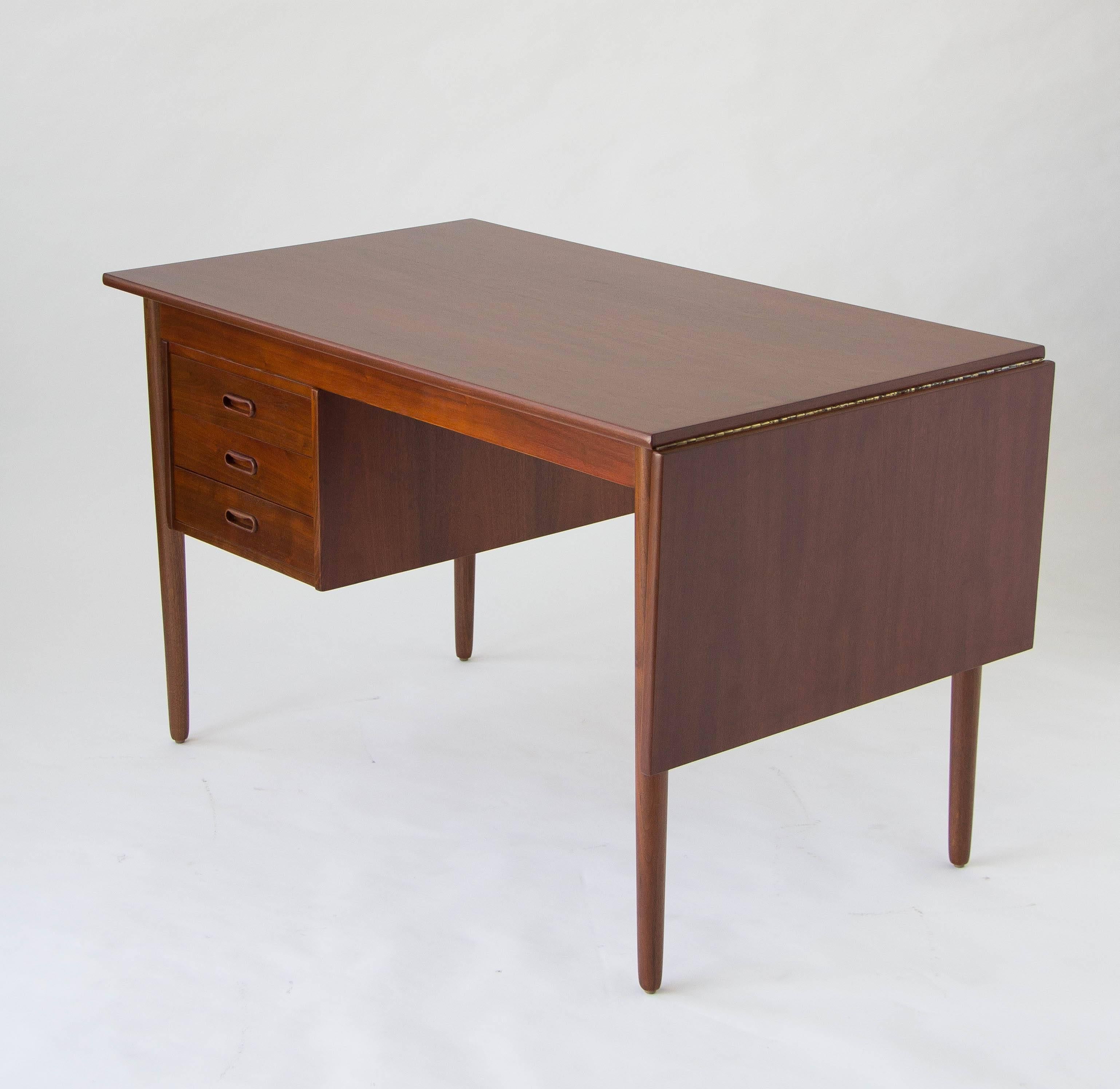 Exceptionally modular teak desk by Arne Vodder. The single drawer stack has three drawers with recessed pulls in matching teakwood. The work space has a dropped leaf on the right side. The whole top slides left to support the leaf and offer a