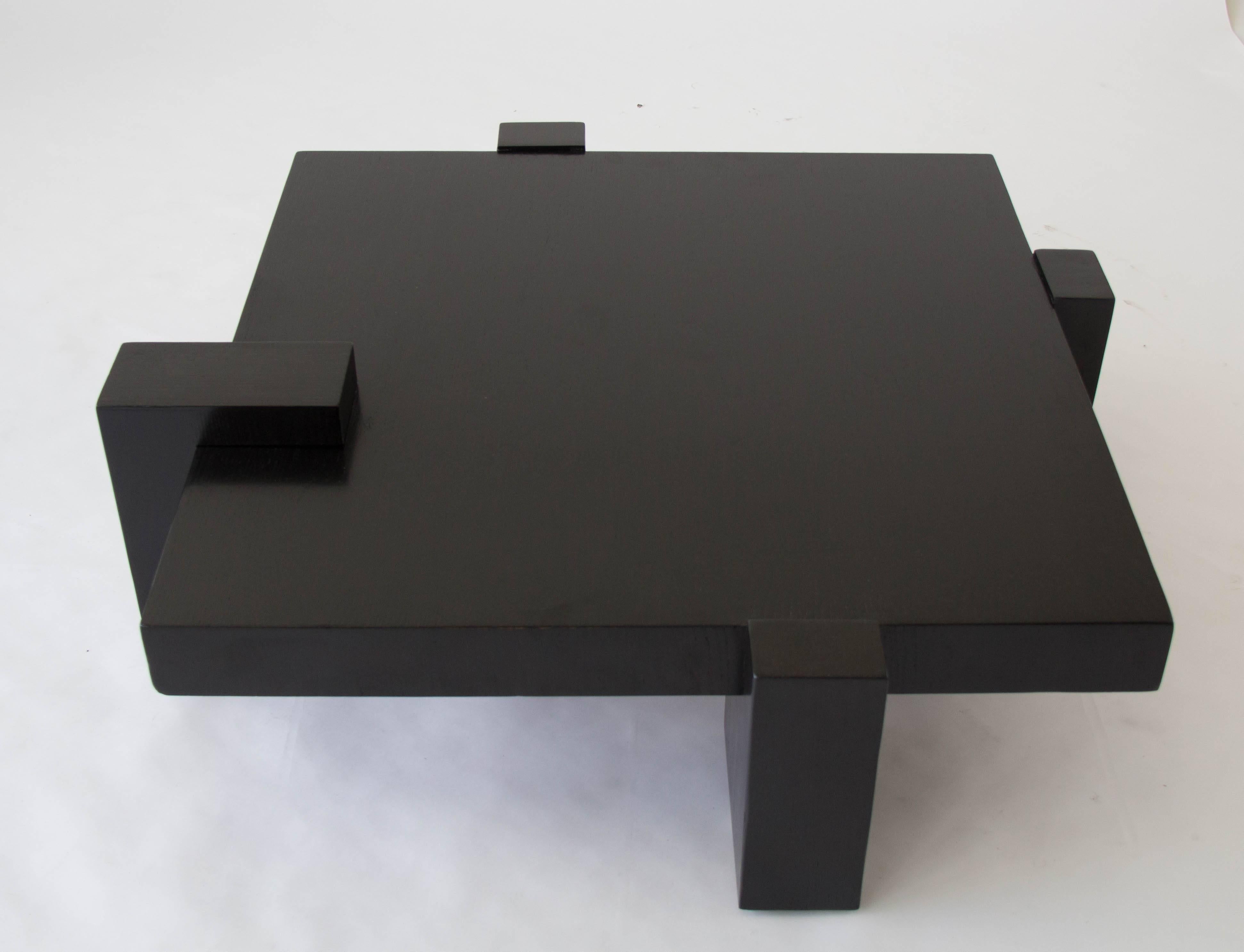 Monumental square coffee table from Kroehler Manufacturing Co. of Naperville, IL. Produced in 1978 the design features a central square slab of ebonized oak, interlocking with four matching support blocks of stylistically irregular height and