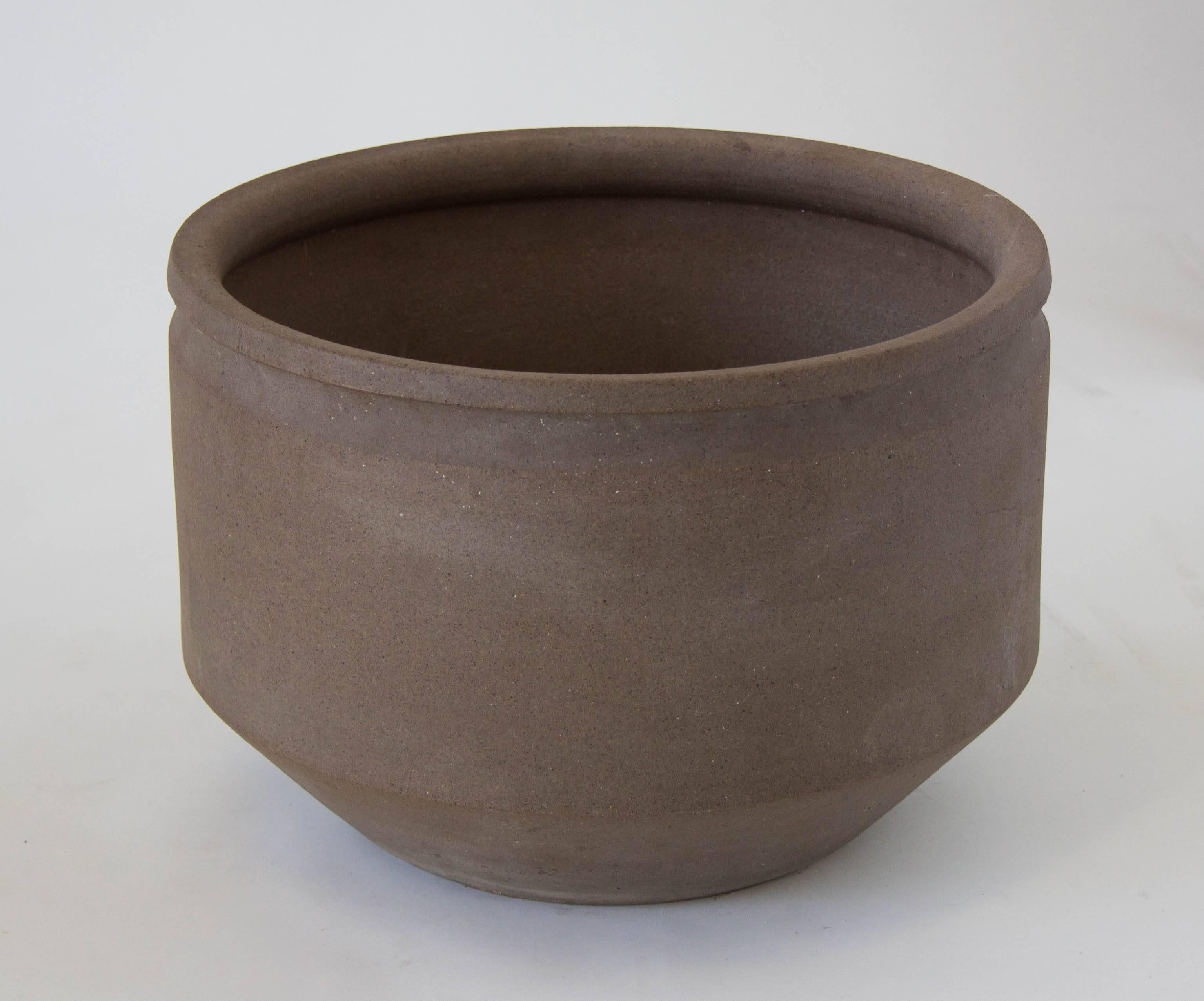 A Minimalist stoneware planter by David Cressey with flat sides angling towards the foot. The unglazed planter has a wide lip. 

Condition: Excellent vintage condition with no chips or cracks. Drainage holes were previously drilled into the bottom