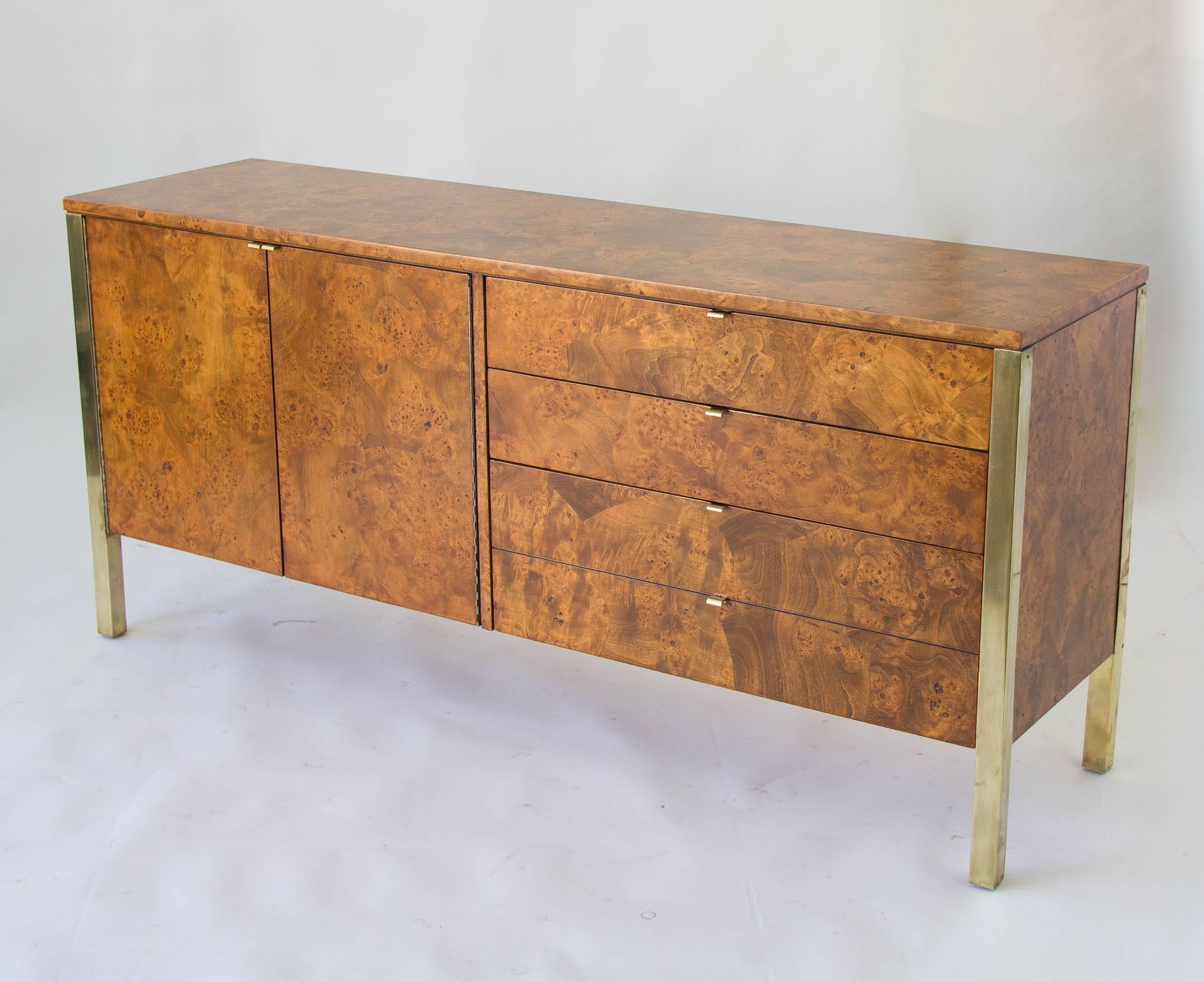 Burlwood credenza or sideboard from Tomlinson Furniture of North Carolina. The right side of the piece has four drawers with brass pulls, and the left side is a cabinet with one shelf. Each corner is encased in a brass piece that extends to form the