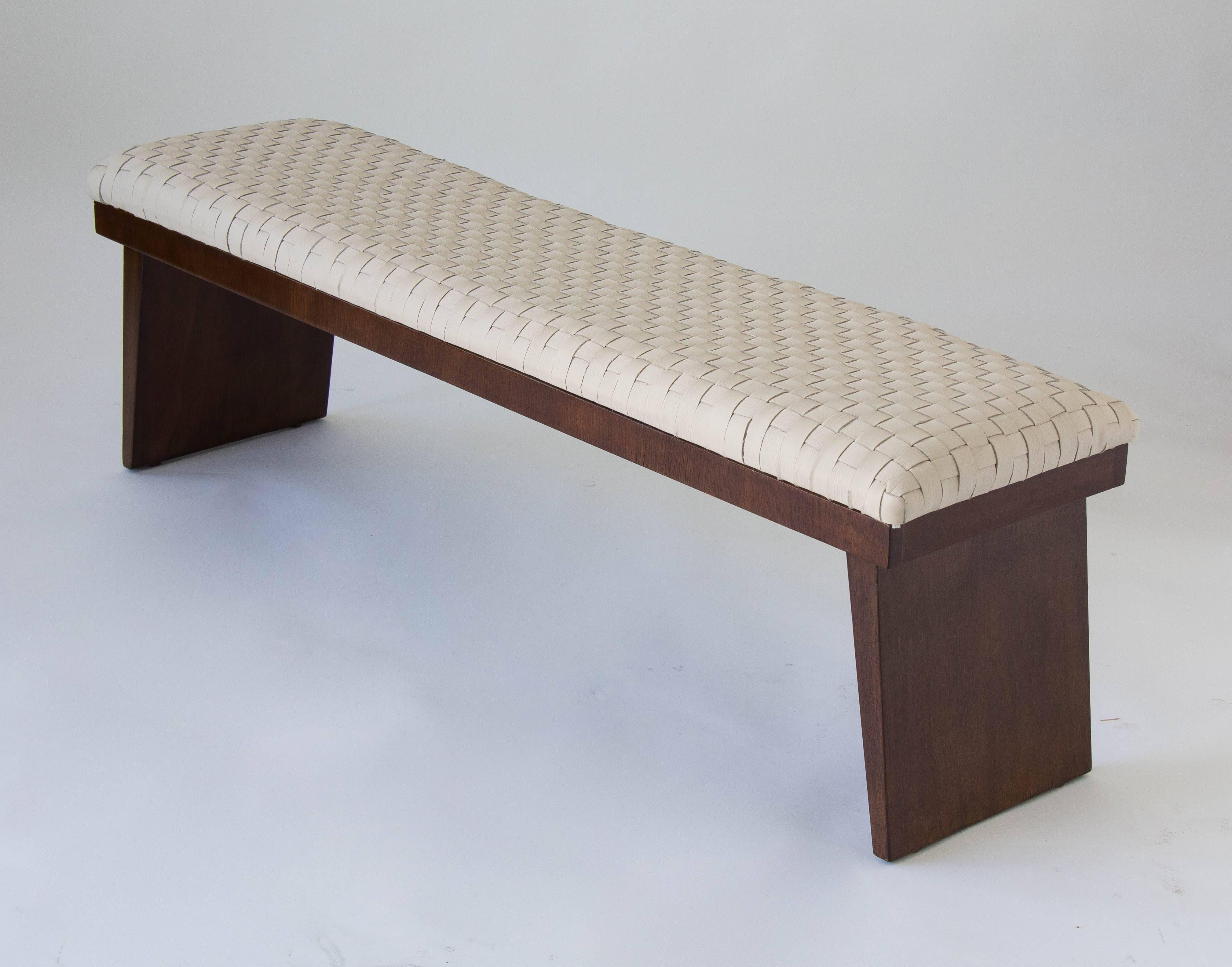 A low bench in walnut wood with two slab legs. The seat is covered in hand-woven top grain leather. 

Condition: Wooden elements have been cleaned and oiled. Foam in the cushion has been replaced. Cushion has been reupholstered in hand-woven