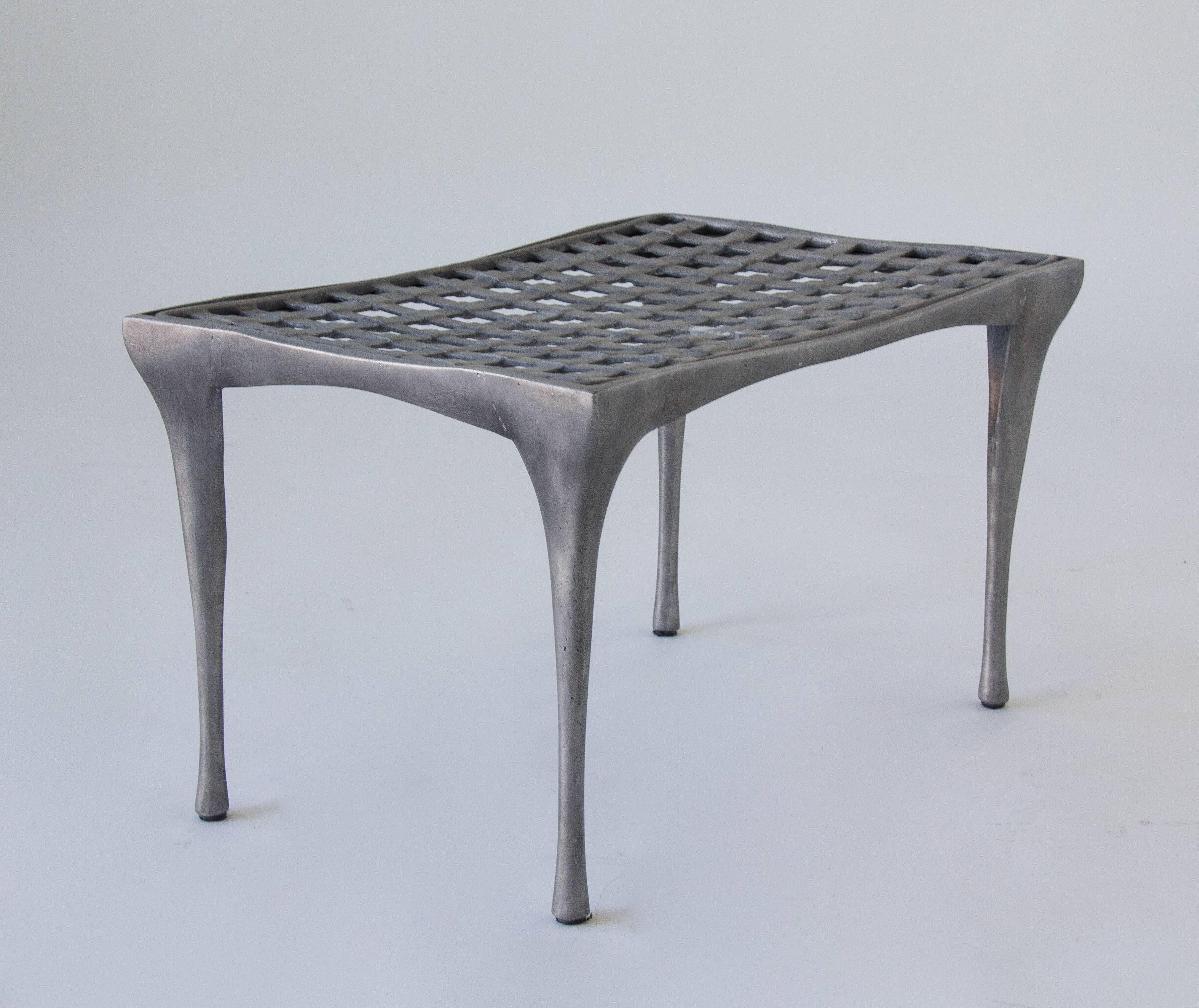 Designed by Dan Johnson and produced by Brown Jordan, this ottoman is cast in aluminum with a “woven