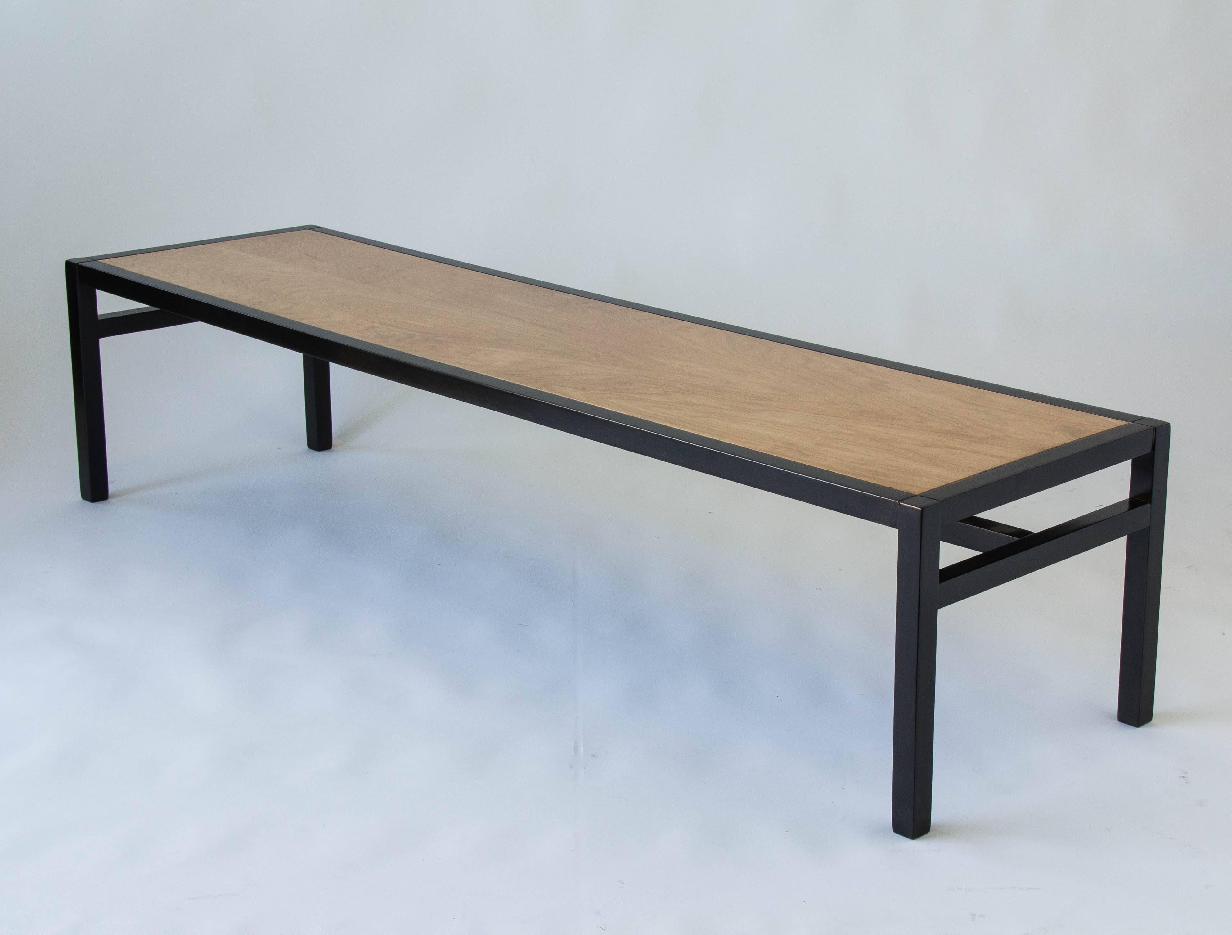A dunbar-esque coffee table with deceptively simple construction and a two tone finish. The square legs are flush with the frame , and both have been ebonized. The contrasting inset tabletop is mahogany wood with subtle grain. Ebonized cross