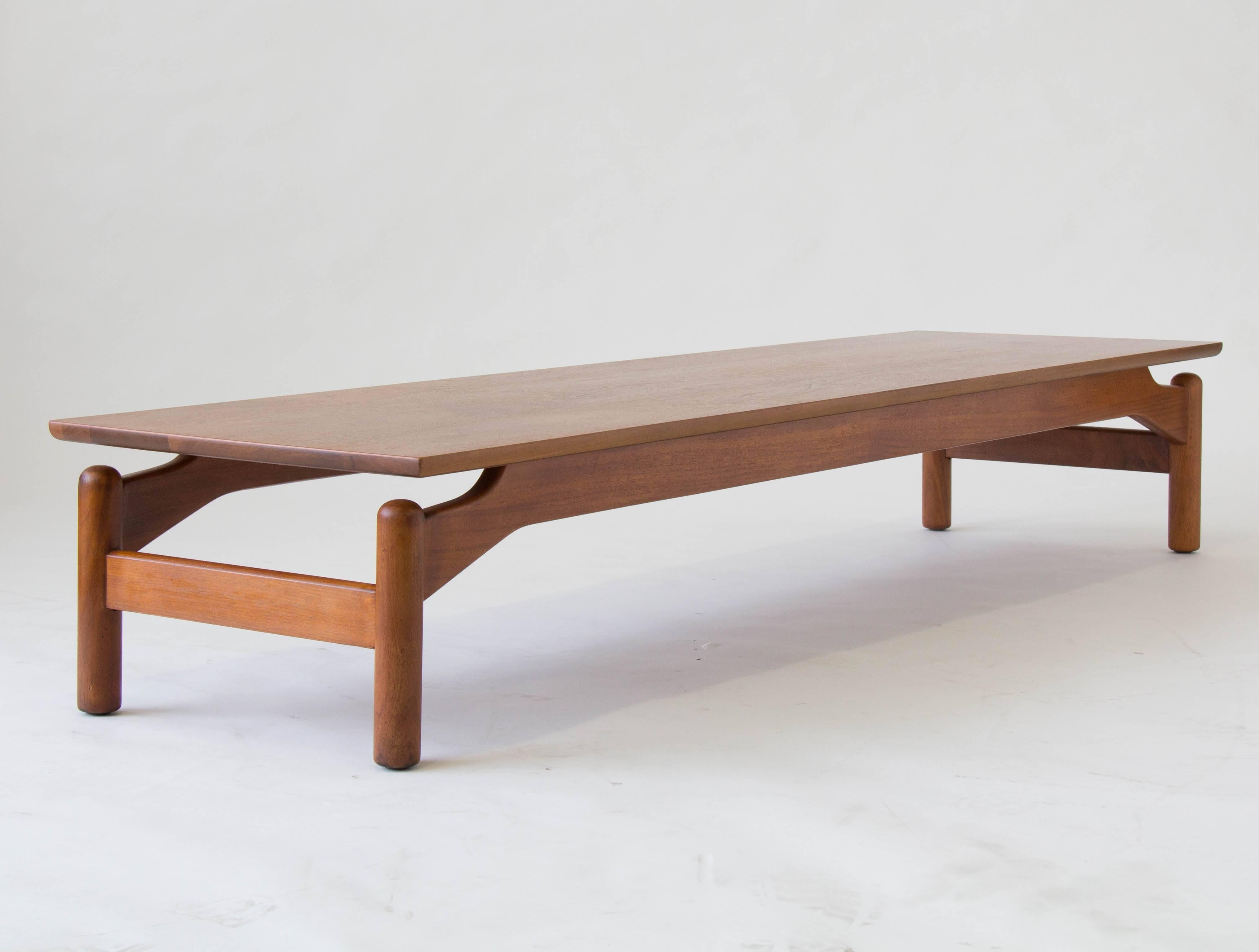A sleek walnut coffee table by Greta Grossman for Glenn of California. The table has a flat plane top that ‘floats’ above four rounded dowel legs and is supported by an arched frame. 

Condition: The table has been professionally refinished and is