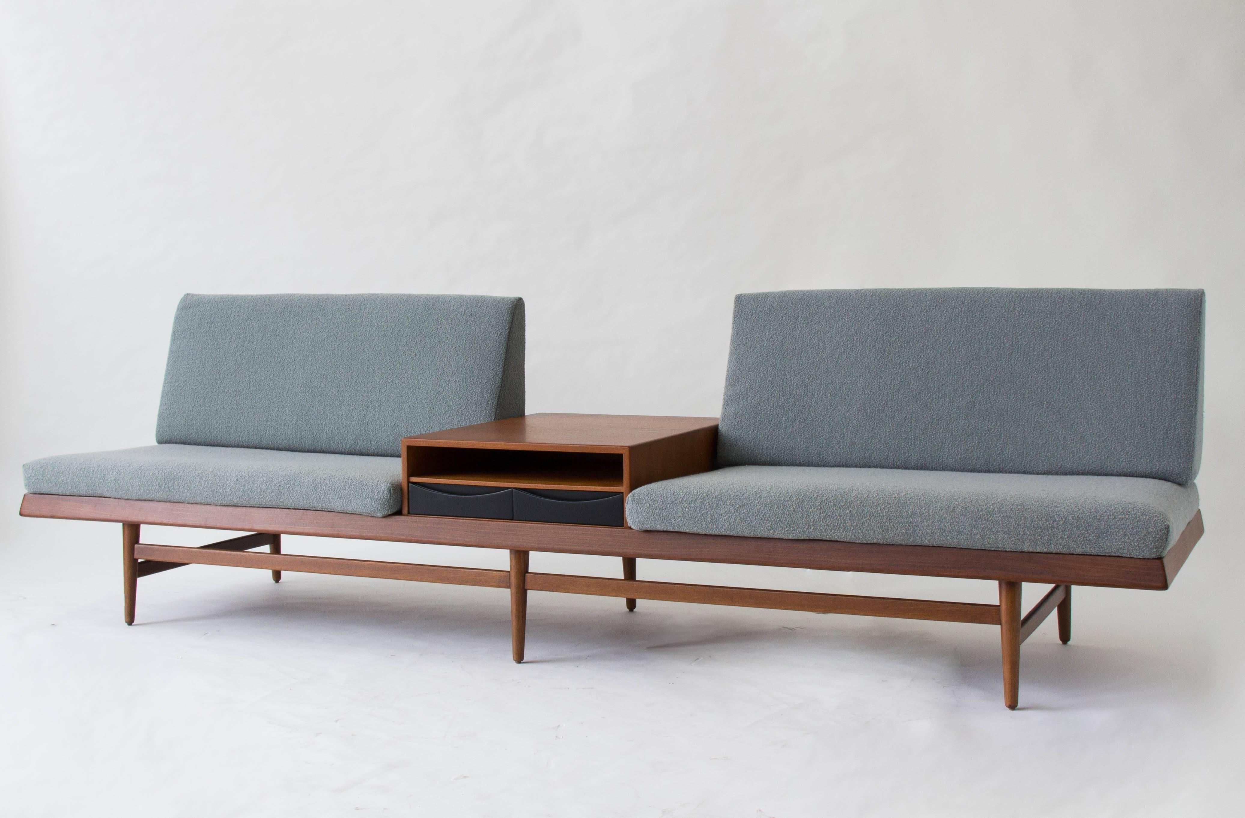 A rare modular sofa designed for Bruksbo by Torbjorn Afdal and produced by B.J. Hansen. The sofa has a teak frame with tapered legs. Two slatted back rests support the removable pyramid-shaped rear cushions. The sofa is fitted with a teak storage