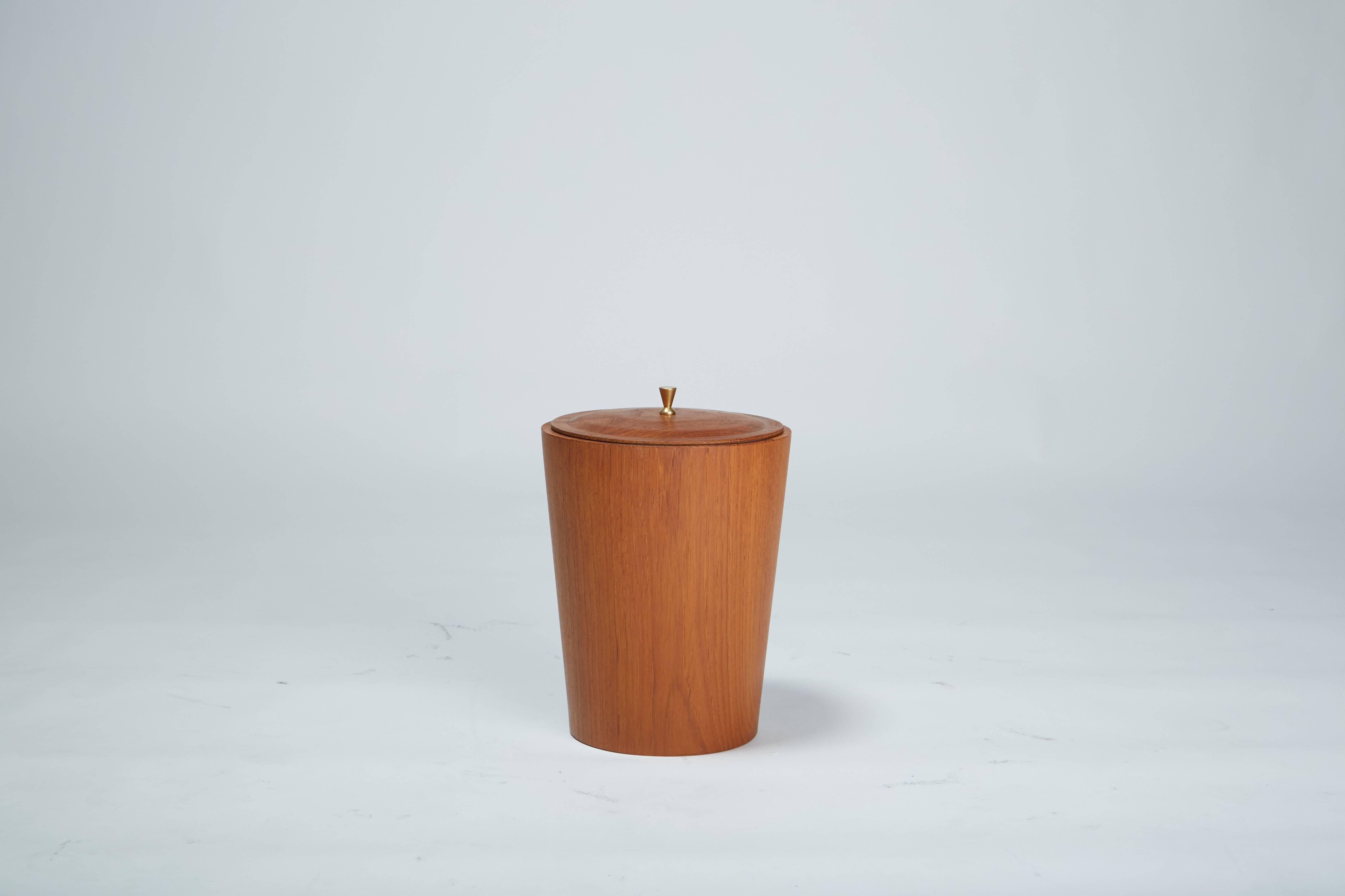 Swedish design house rainbow wood products specialized in streamlined home and office accessories in teak veneer. This example is an ice bucket with a delicately flared conical shape. The white plastic interior sleeve lifts easily out for cleaning.
