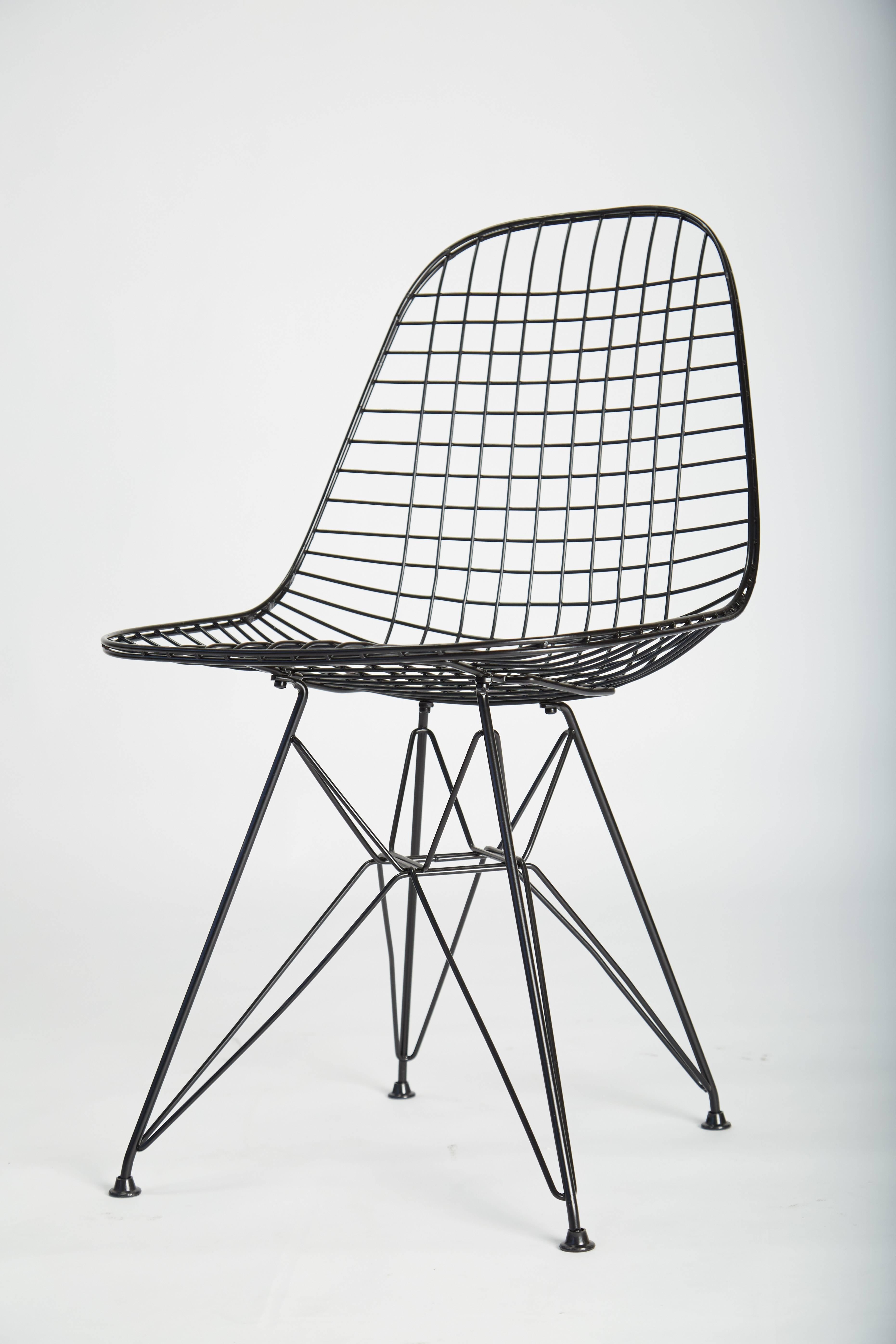 A pair of restored wire chairs with "Eiffel Tower" base. The frame is formed by a web of crossed wires and is fixed to a wire base with sculptural lines. These examples have been powder-coated and are suitable for indoor or outdoor use.