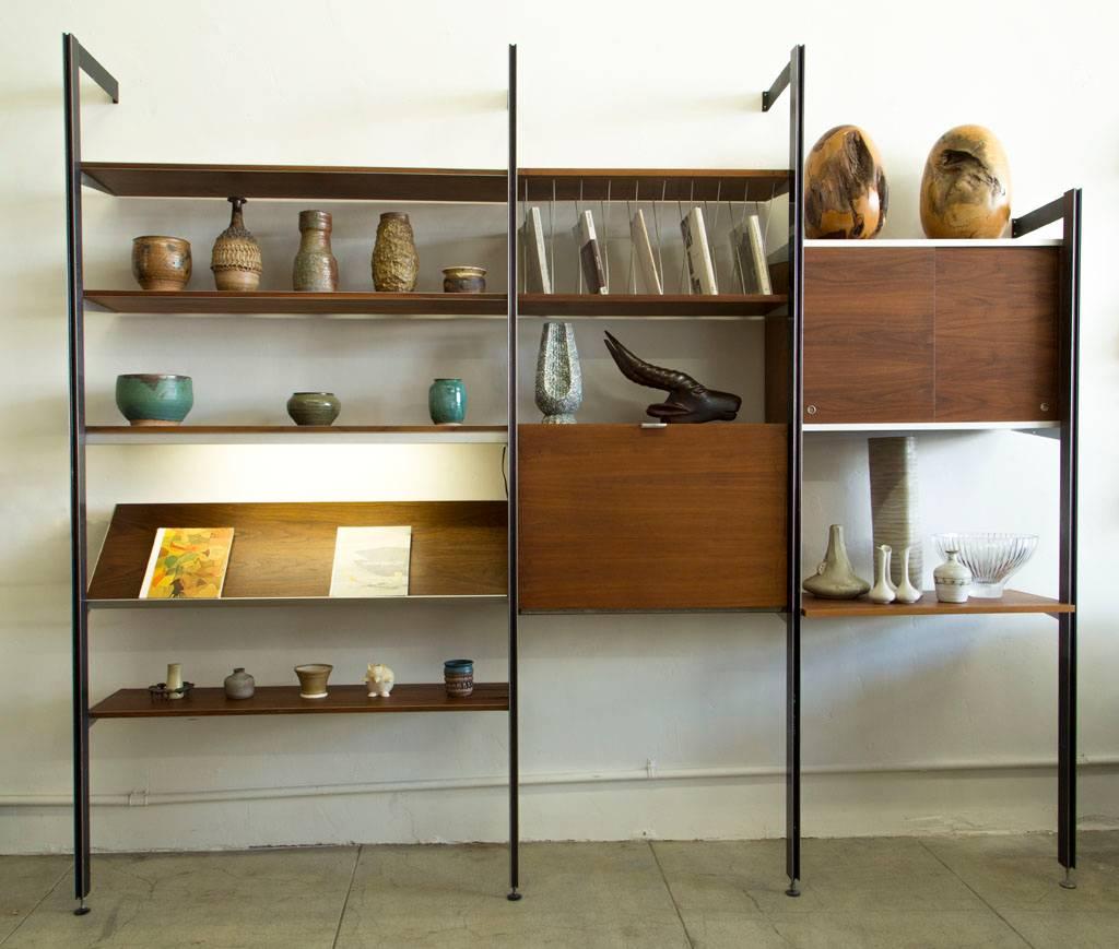 A three-bay CSS wall unit designed by George Nelson for Herman Miller. This example has four uprights - three at 96”, and another at 84” height. The bay left-hand bay has a width of 48”; the remaining bays are 32” wide. The unit includes a 48