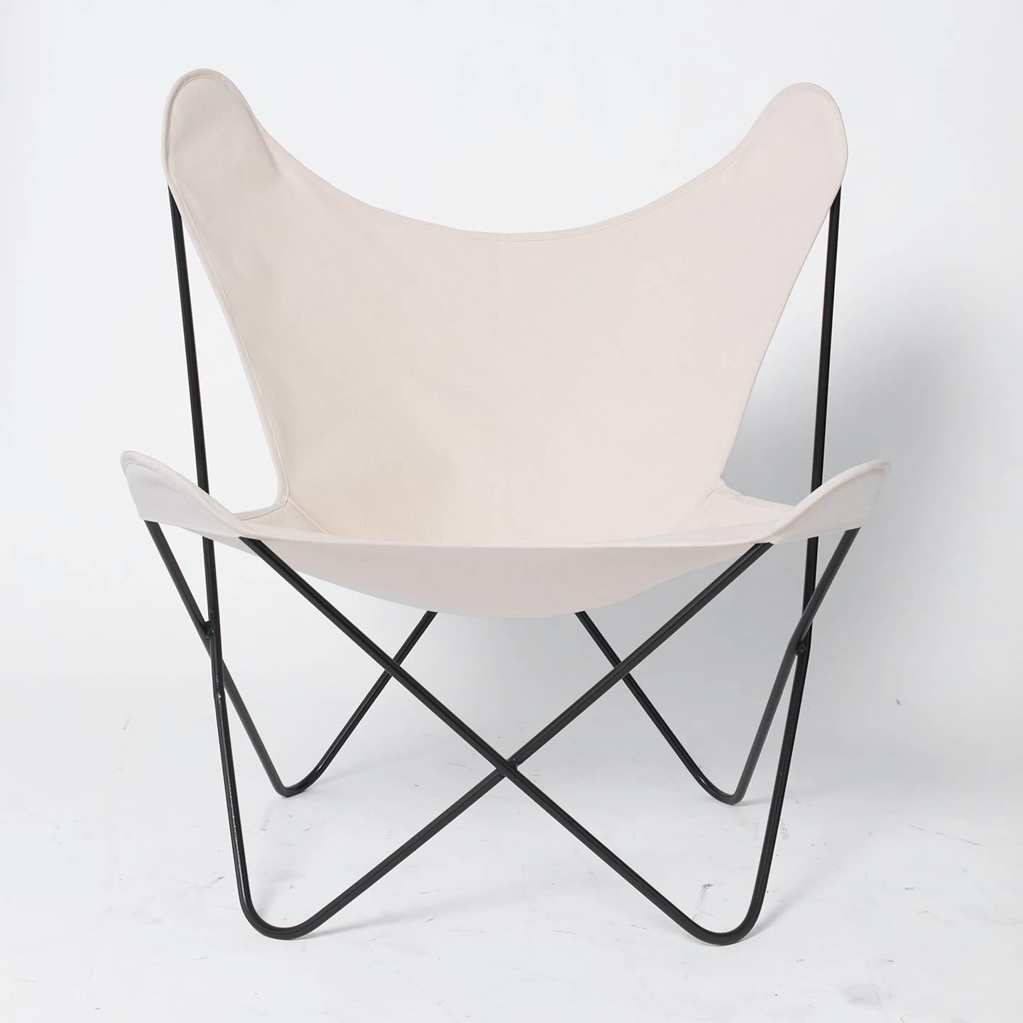 Two Jorge Ferrari-Hardoy designed butterfly chairs with new, natural canvas slings. The chairs have a solid frame of welded iron, powder-coated for a matte black finish. This pair of chairs measures 32" across the widest point of the