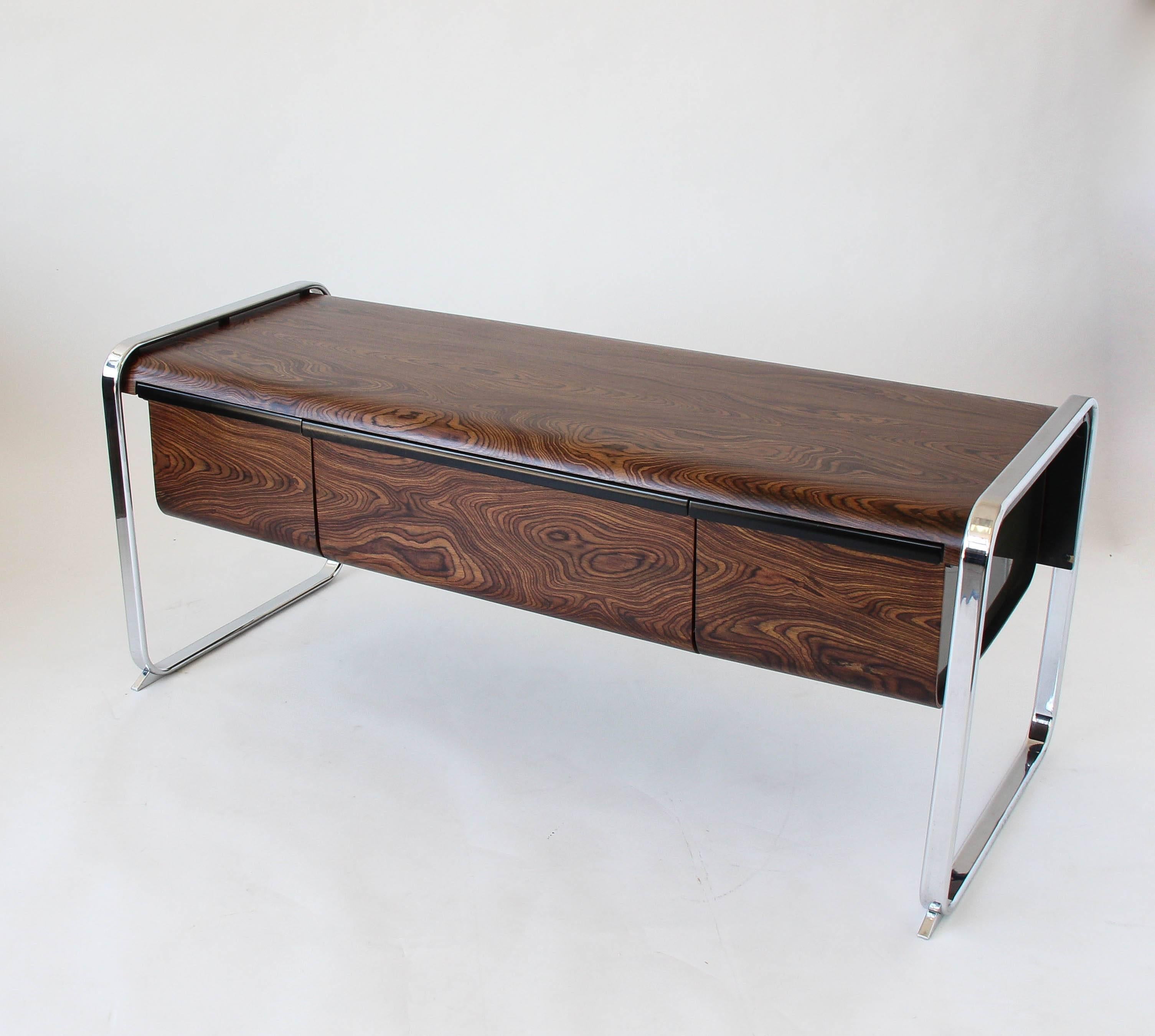 Office credenza from Peter Protzman's Tubular collection for Herman Miller. Manufactured only from 1970-1971 the design features a case of zebrawood veneer suspended between two frame runners of chrome-plated steel. The credenza has three deep