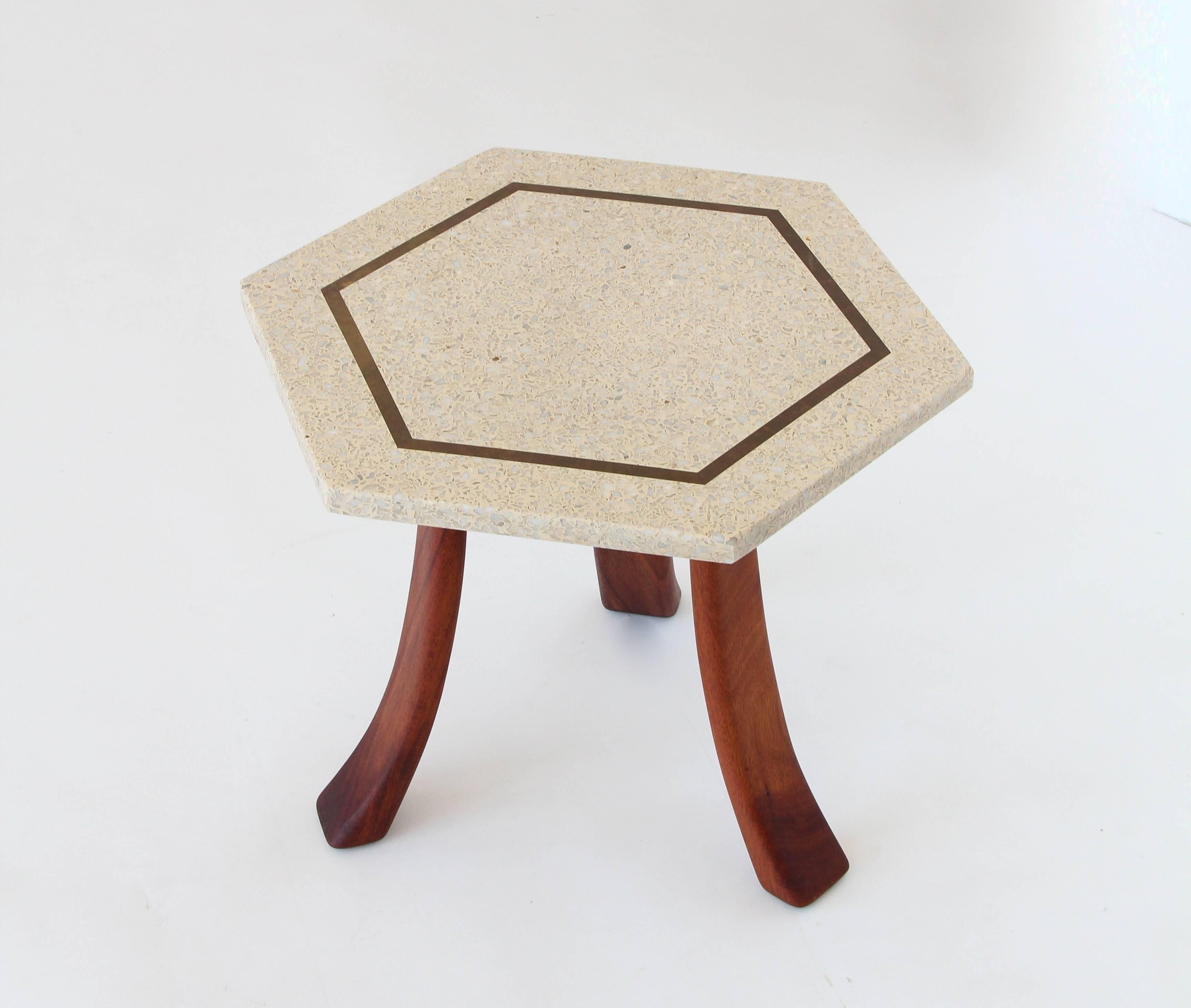 A distinctive side table with a hexagonal top and flared sabre legs by Harvey Probber. The tabletop is in a white terrazzo with an inset hexagon detail in brass. The flared legs are solid walnut. 

Condition: Excellent vintage condition;