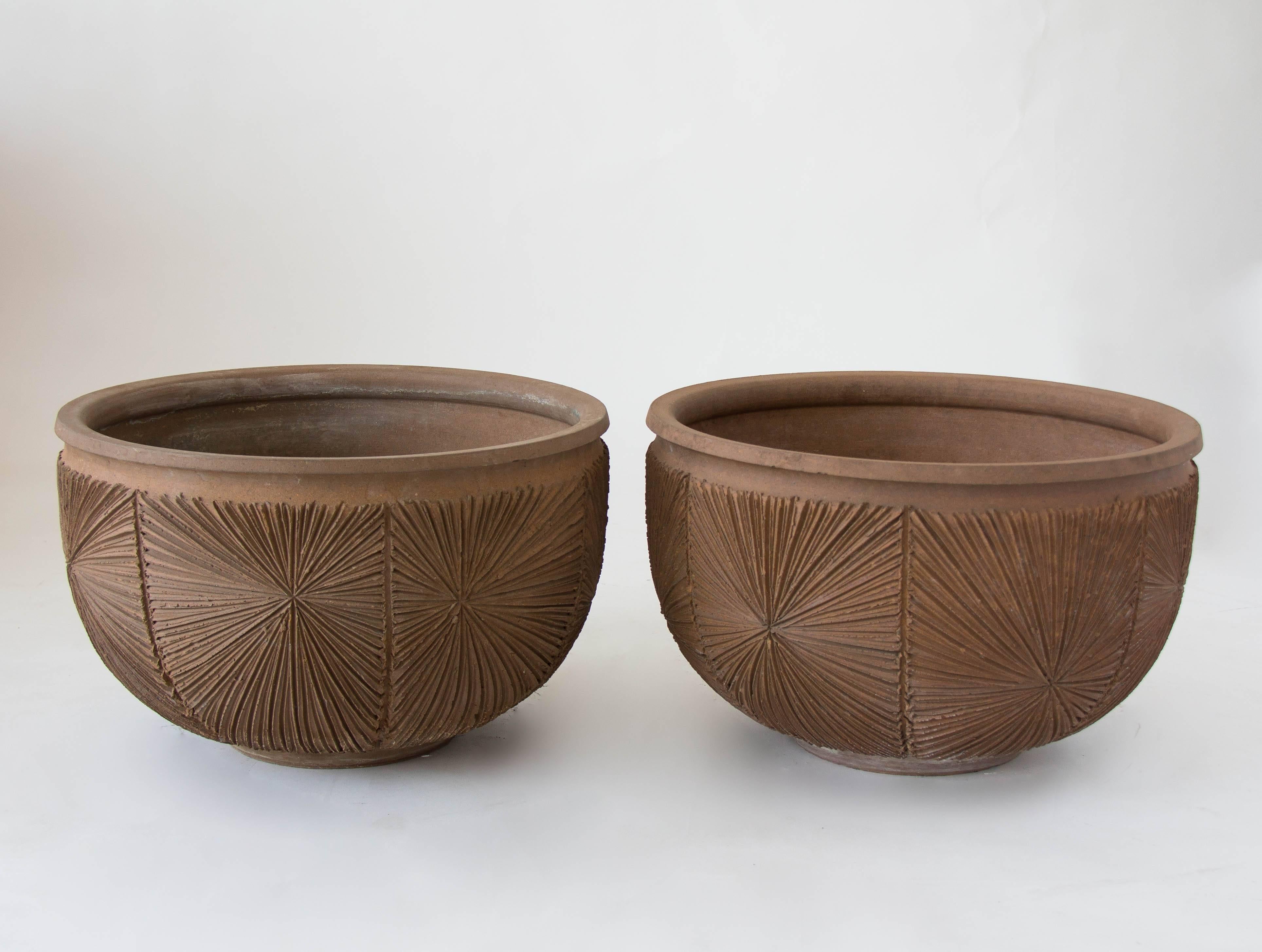 A stoneware bowl planter from Robert Maxwell 1970s collaboration Earthgender. The planter has a rounded lip and an incised all-over sunburst pattern and is unglazed. We have two planters available in this shape and size and the listed price is per