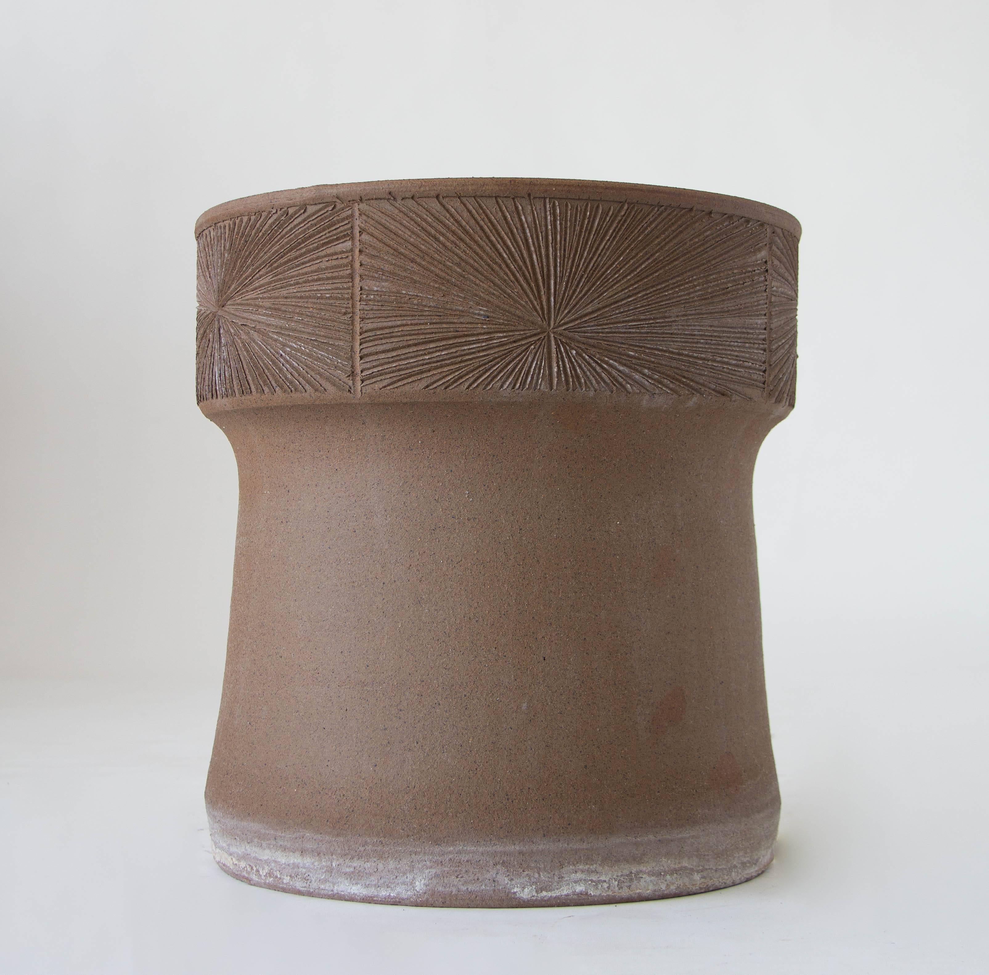 A stoneware planter Robert Maxwell 1970s collaboration Earthgender. The planter has plain sides flared towards the foot, and a wide lip with an incised sunburst pattern. The interior of the planter is glazed. 

Condition: Excellent vintage