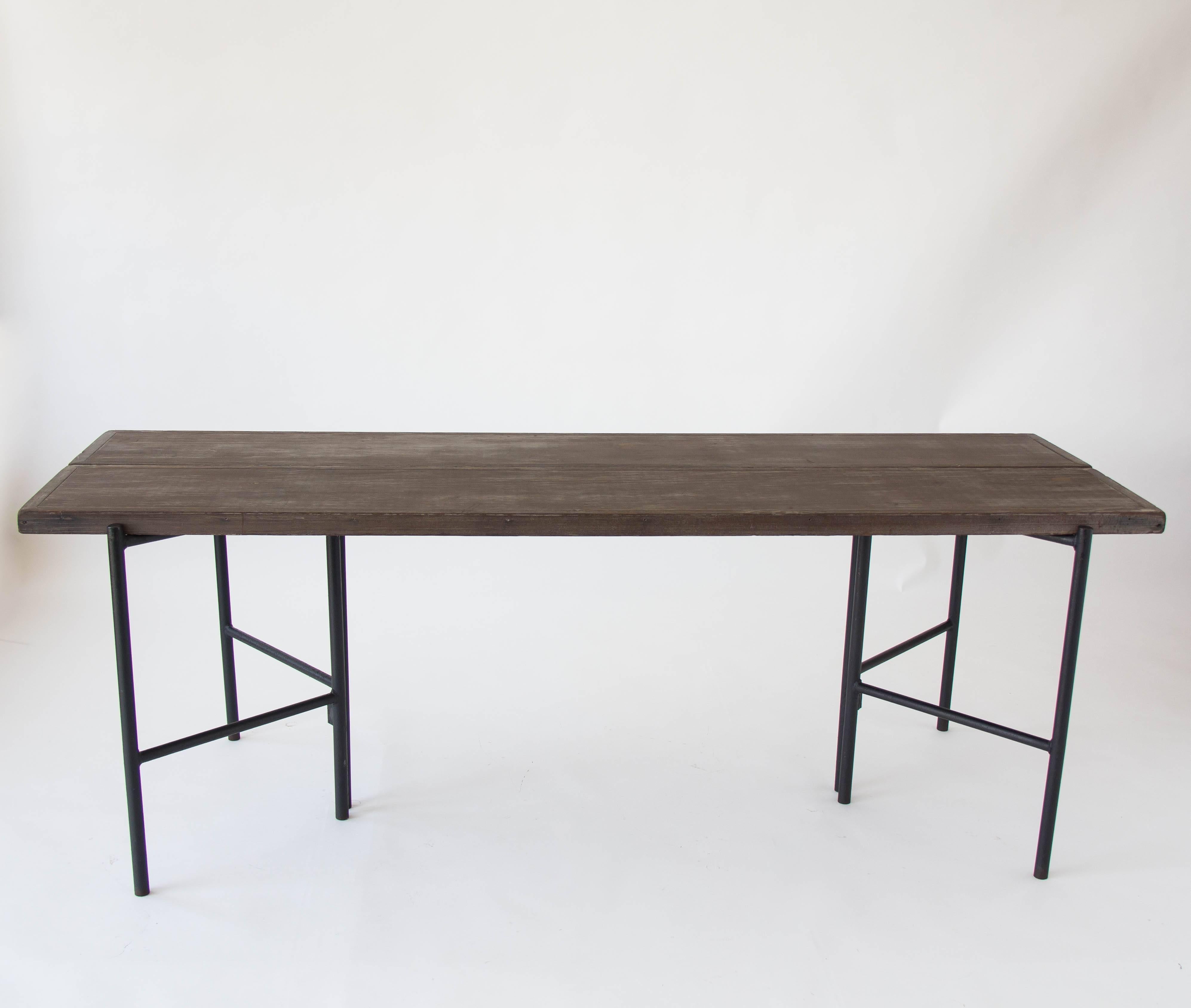 The refectory table by Hendrik Van Keppel and Taylor Green has a modular gate-leg design. Two brackets of enameled steel can be positioned to support two long boards of aged redwood as a slatted table. Or the brackets can be rotated and the boards