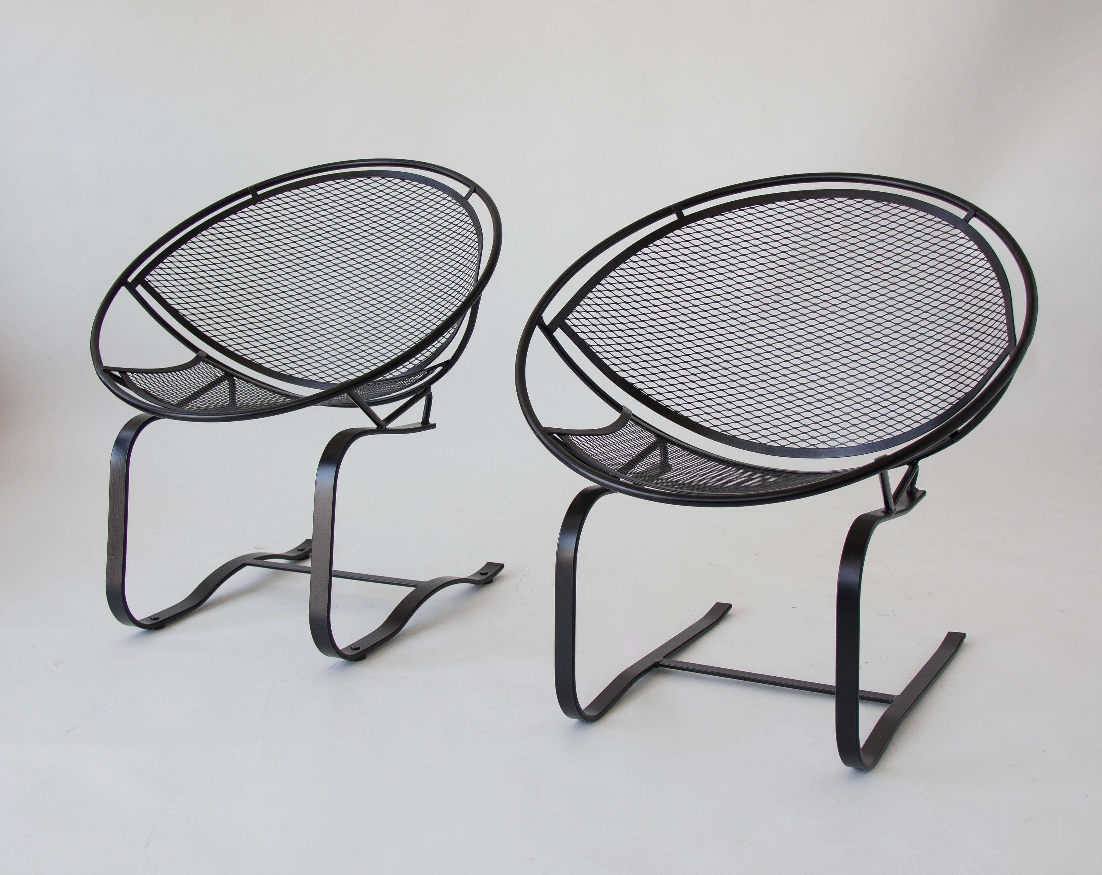 Two wrought iron patio rocking chairs from the “Radar” line, designed by Maurizio Tempestini for John Salterini. Each chair has a bisected hoop construction with a delicate grid of wrought iron forming the body. The cantilevered design sits on two