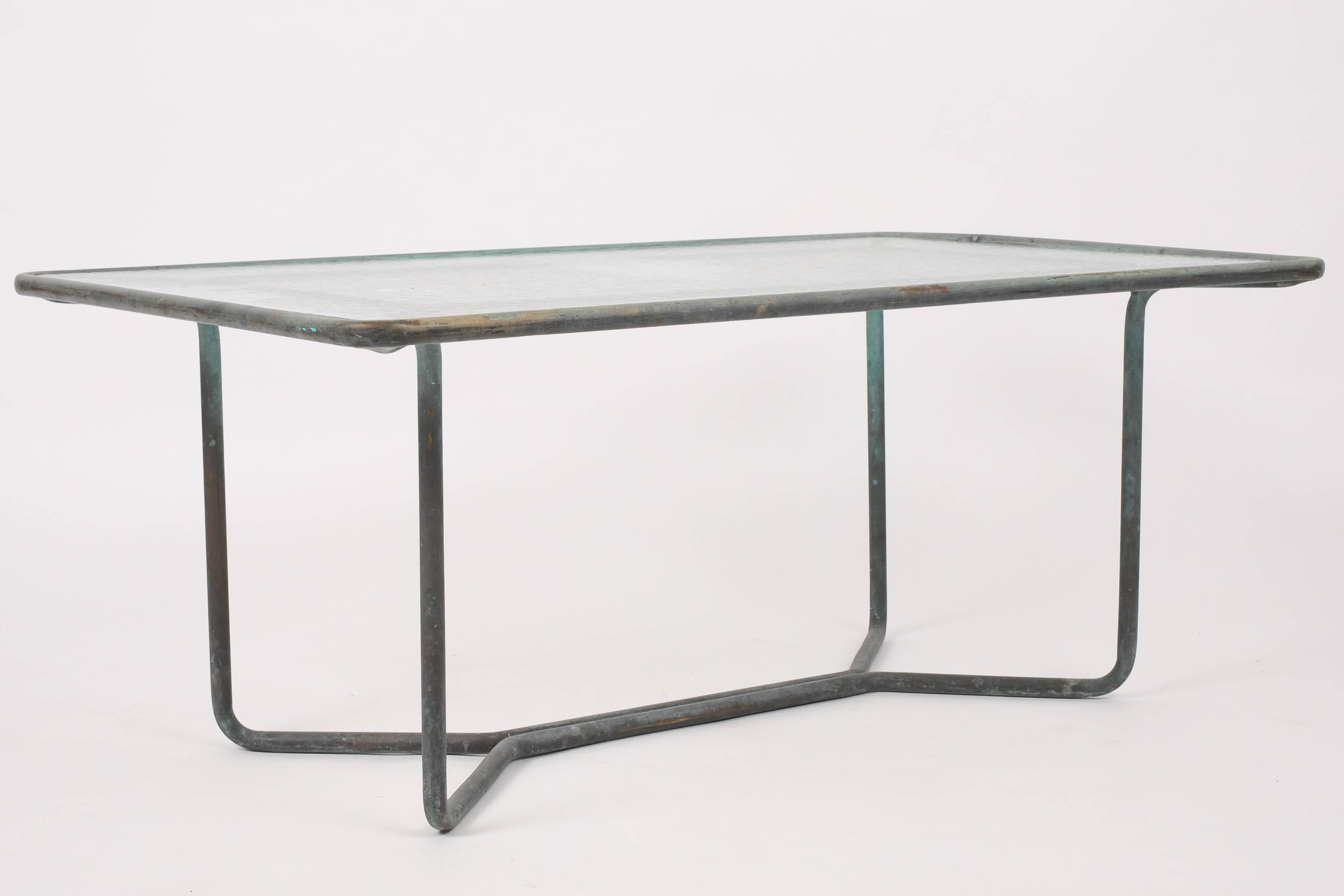 A patio coffee table in patinated bronze designed by Walter Lamb and produced by Brown Jordan. The table has a rectangular shape with rounded corners, supported by four hairpin legs in matching bronze. The legs are joined by diagonal stretchers and