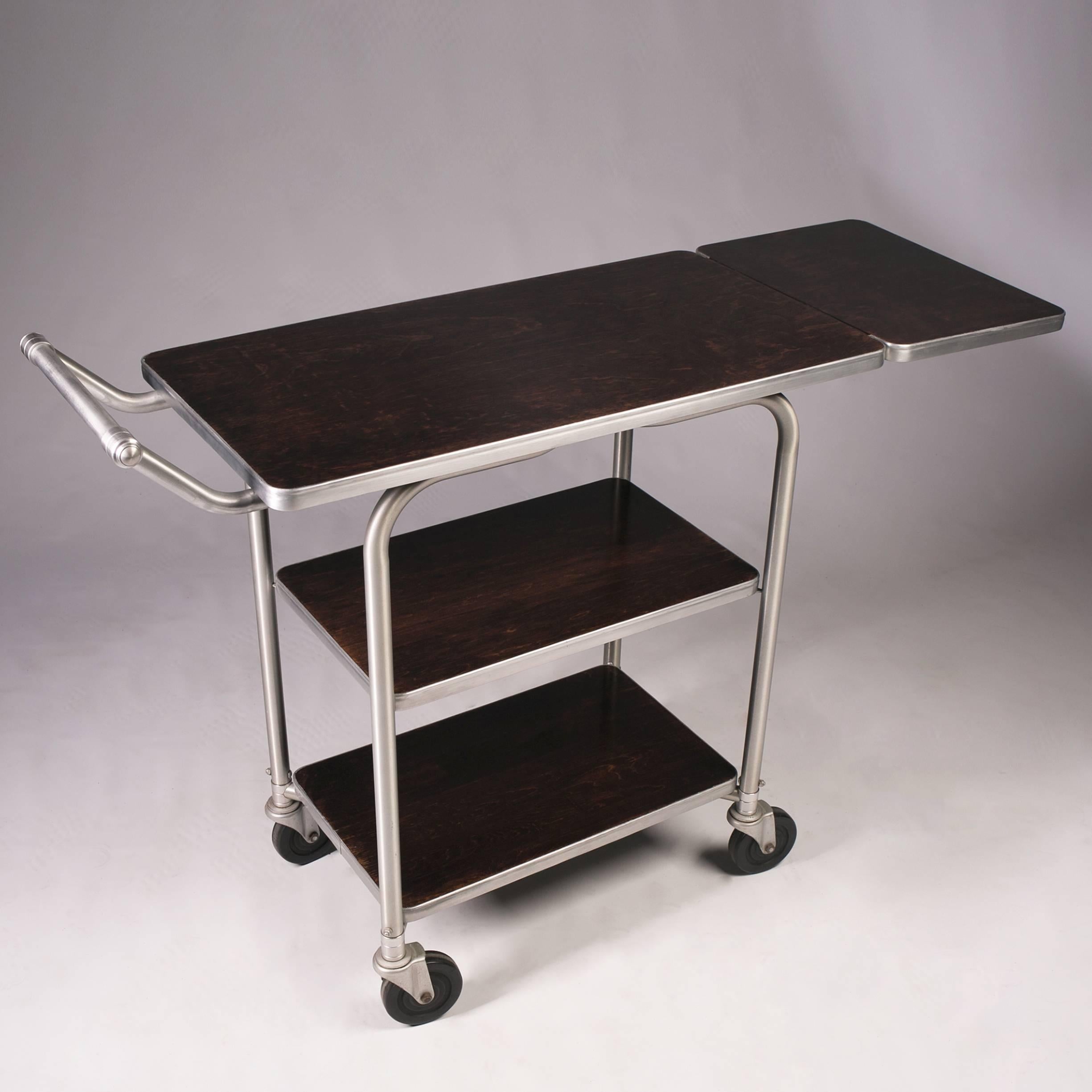 Three-tier cart with casters. Wood surface in a dark brown finish.