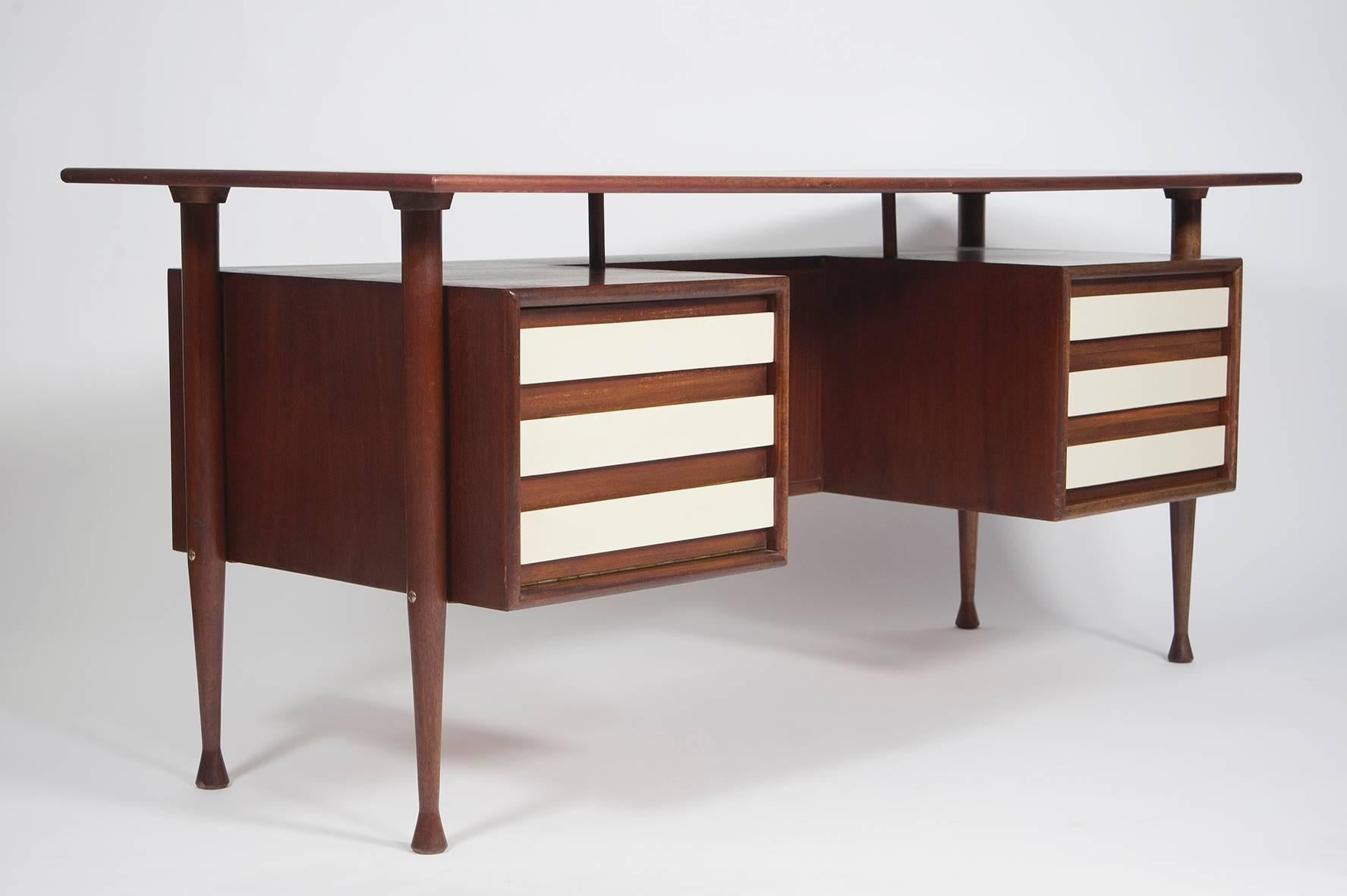 Rare Mid-Century Modern mahogany desk from the German 1960s with organic shaped table leaf, different drawers and bookshelf on the back.