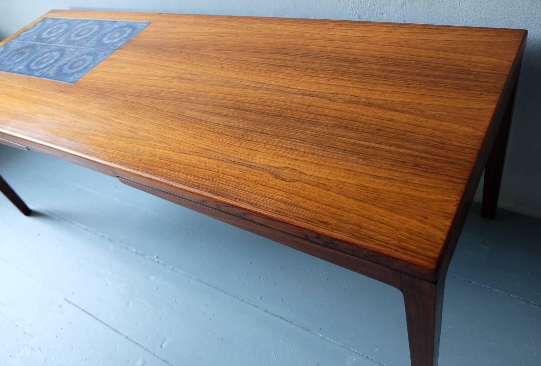 Coffee table in rosewood from Denmark, circa 1960.
The table has finely made mosaic ceramic tiles set into the wood and has an unusual design.
 