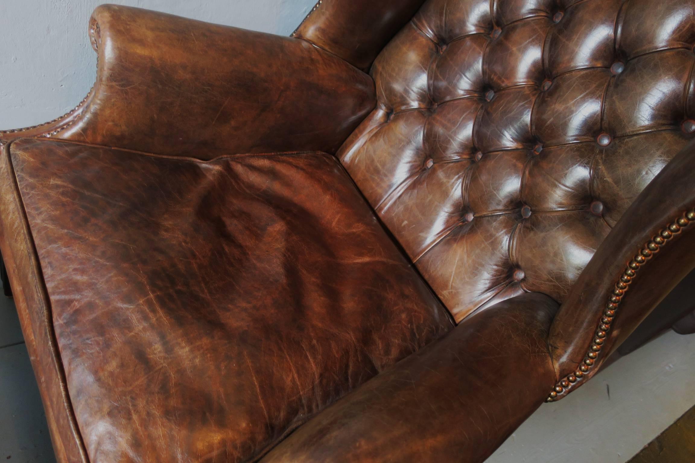 Very attractive dark brown leather Chesterfield wingback armchair with ottoman.

Very good condition.
