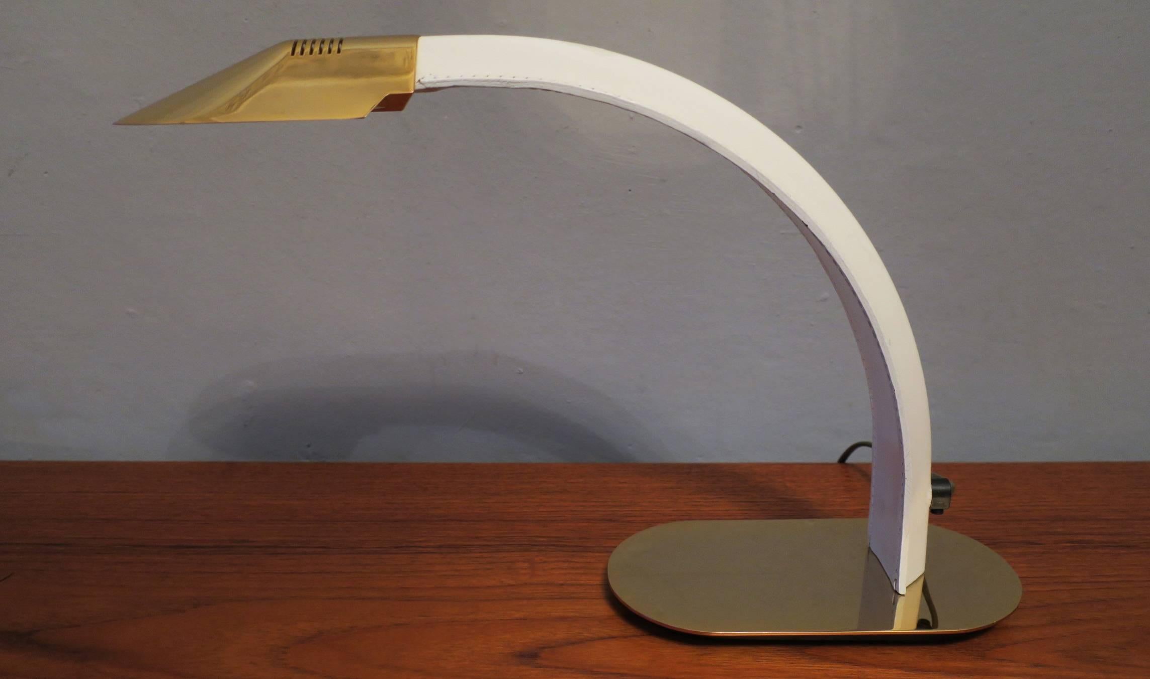 Cobra desk lamp of gilt metal with a curved support of stitched leather, inscribed.