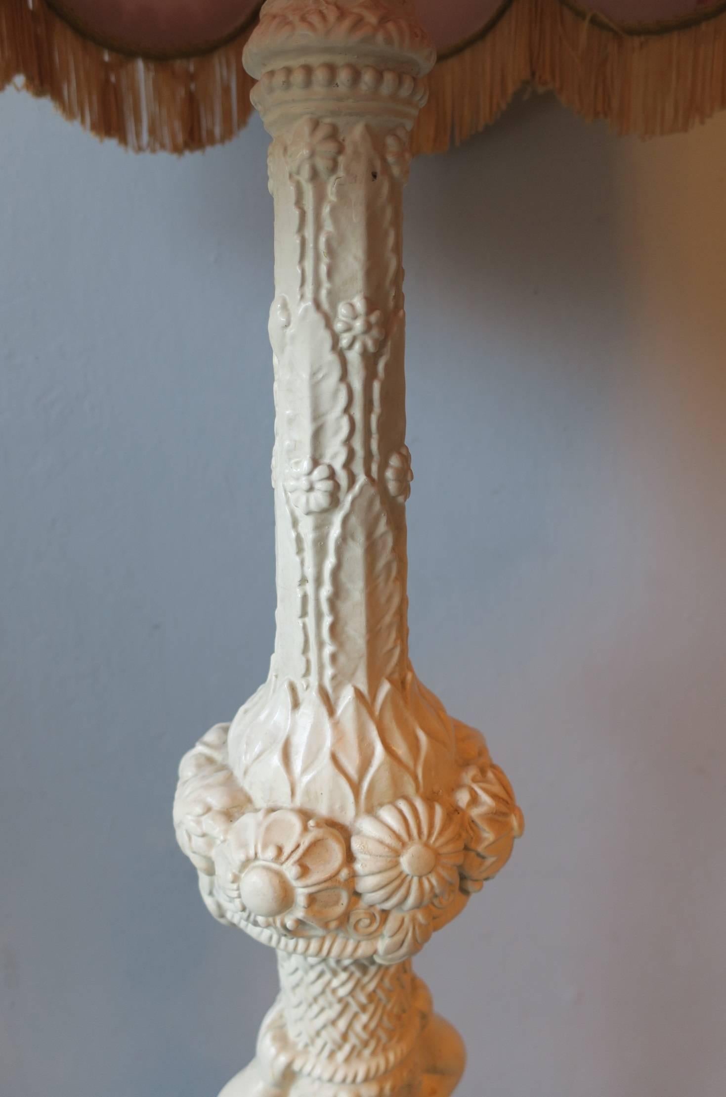 Carved and painted wood floor lamp with a putto carrying the light, original silk shade and finial.

Measures: Height 75 ins (190 cm).
Diameter of the foot 15 ins (38 cm).
Diameter of the shade 24 ins (60 cm).
       