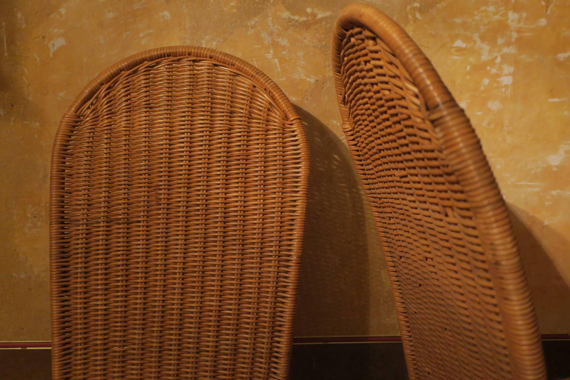 Set of four elegantly designed Mid-Century rattan and iron chairs in very good condition.