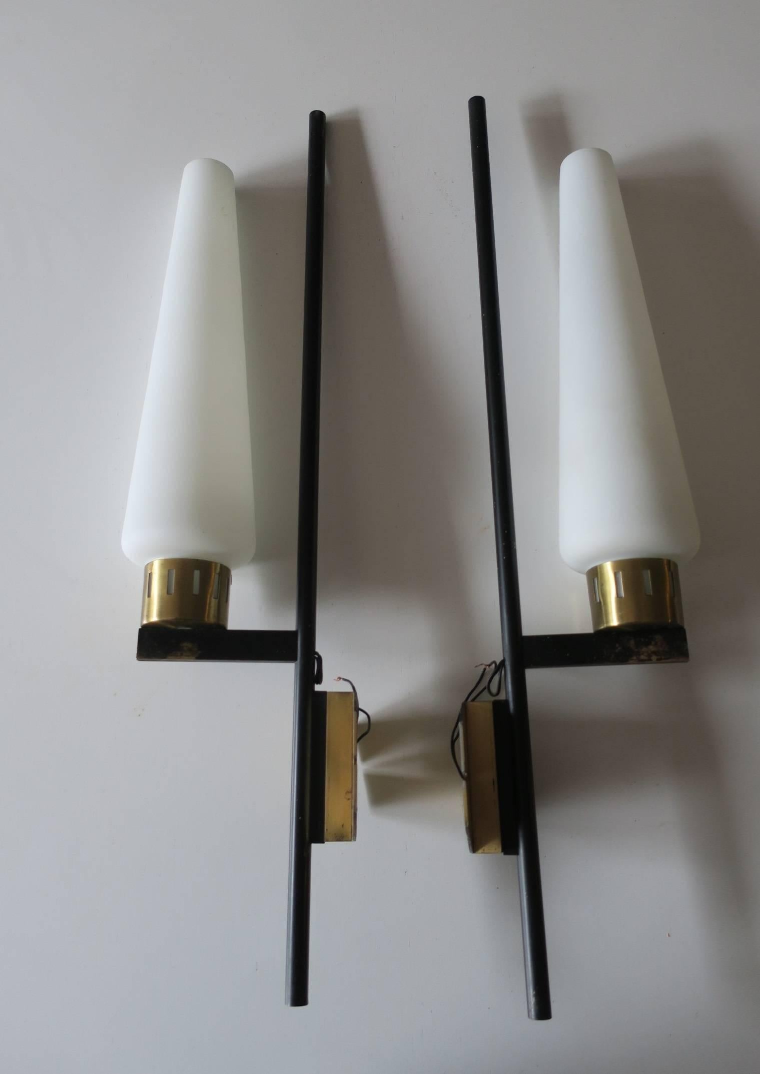 Pair of elegant Italian brass and glass sconces with slender black metal supports on patinated brass frames holding narrow matt milk glass shades.