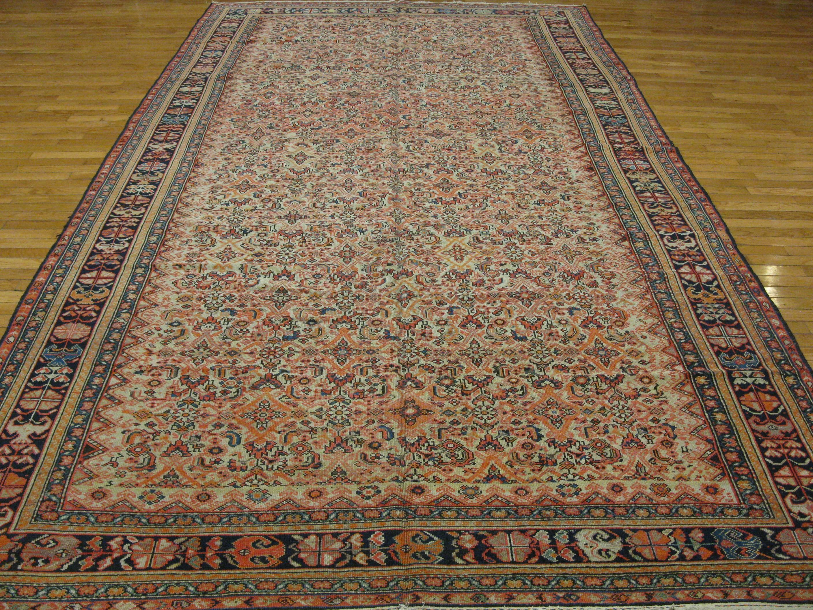 This beautiful hand-knotted gallery size rug was made in the village of Malayer in Iran (Persian). The rug has an all-over Herati pattern made with wool dyed with natural colors on a cotton foundation. It measures 7' x 13' 2''.