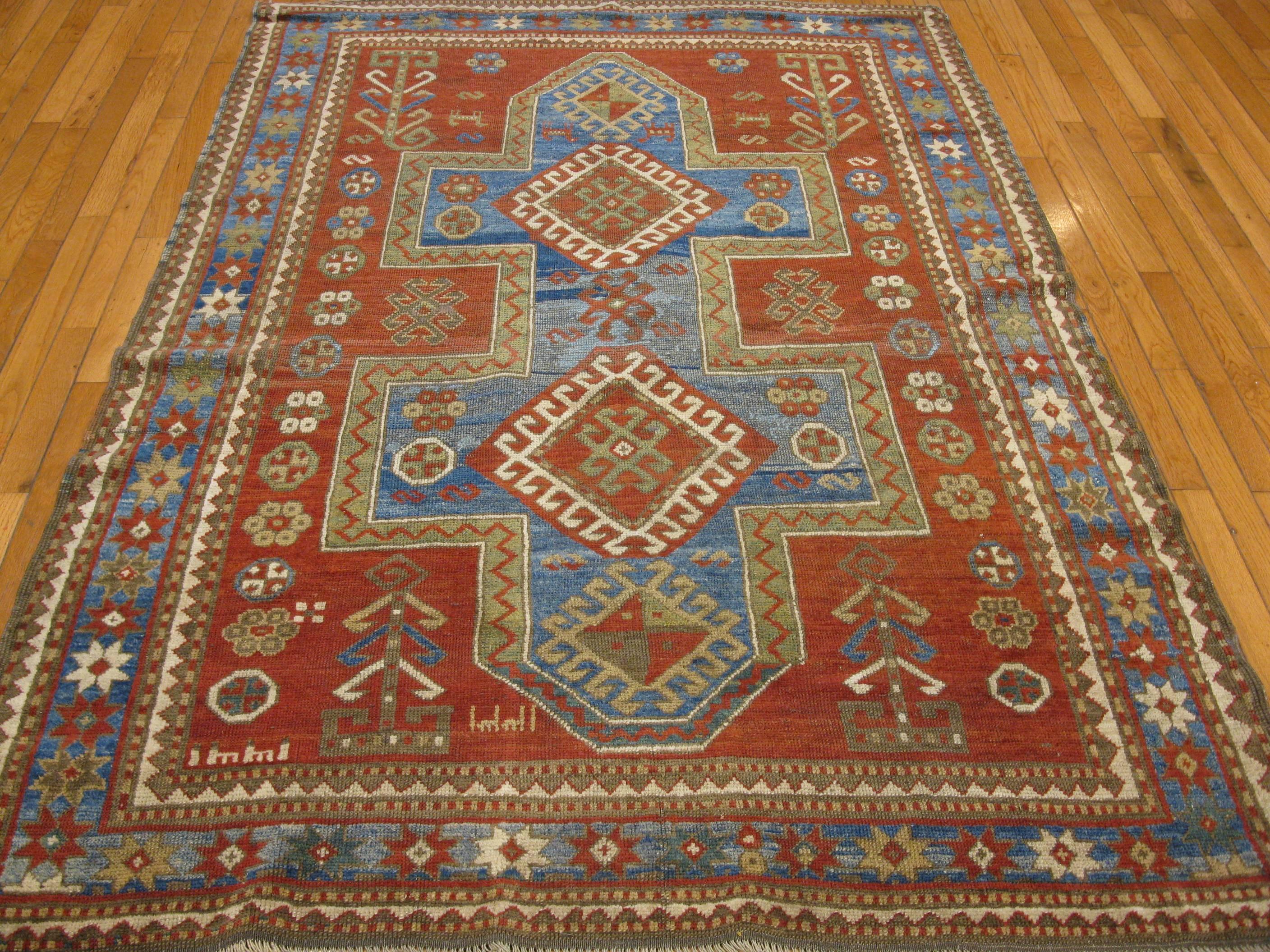 This is a beautiful antique hand-knotted Caucasian Kazak rug with a tribal geometric design usually associated with rugs from this region. The rug measures 4' 6” x 7' made with 100% fine wool colored with all natural dyes.