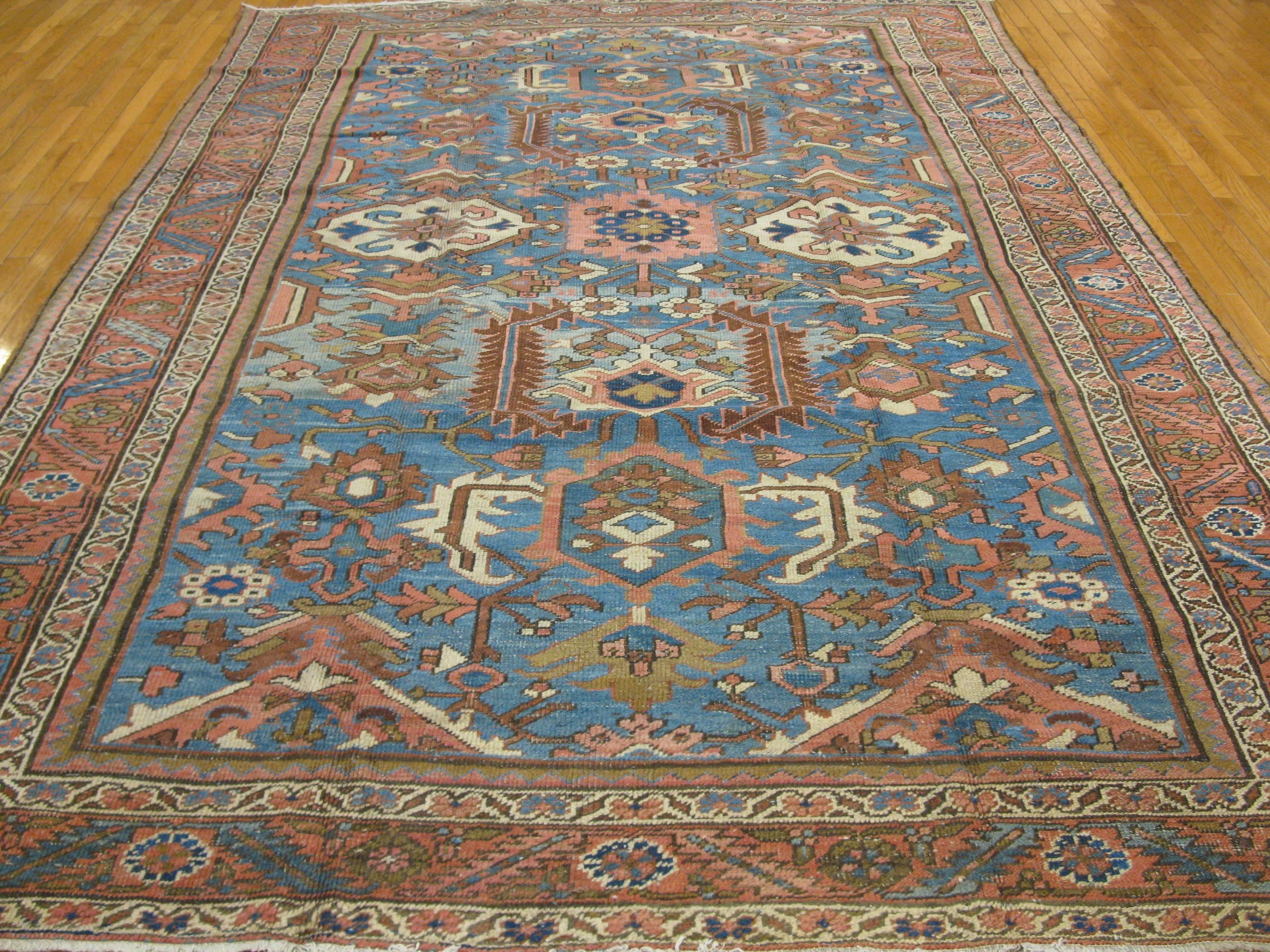 This is a beautiful and hard to find antique hand-knotted Persian Serapi rug with a beautiful soft blue color background and soft brick red border. Its all-over pattern makes it an easy rug to work with. The rug measures 8' x 11' 4'' and is in great