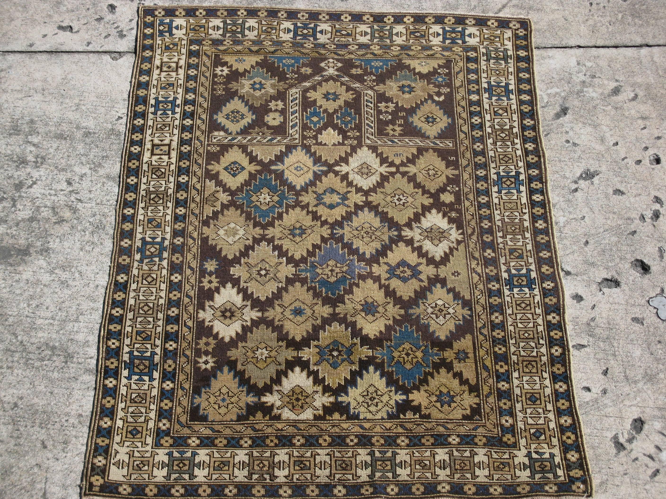 This is an antique hand knotted Caucasian Kazak rug. It has a geometric Mehrab design with a repetitive all-over pattern in all natural earth tone colors.
It is a beautiful rug to hang or use on the floor. It measures 3' 10'' x 5' 4''.