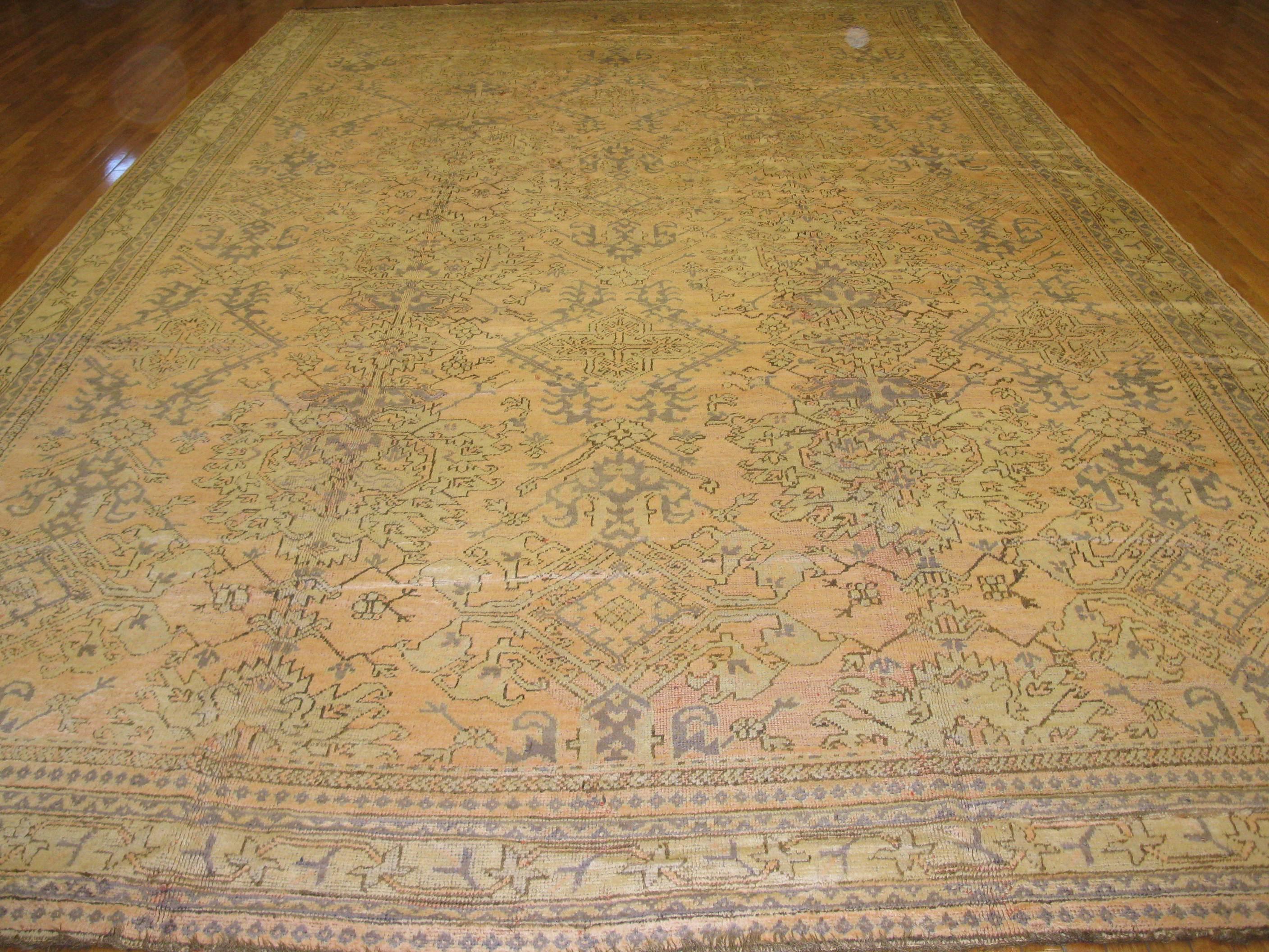 This is a large antique Turkish Oushak rug with an all-over geometric design made with fine wool. Antique washed. The rug measures 11.6'' x 19'.