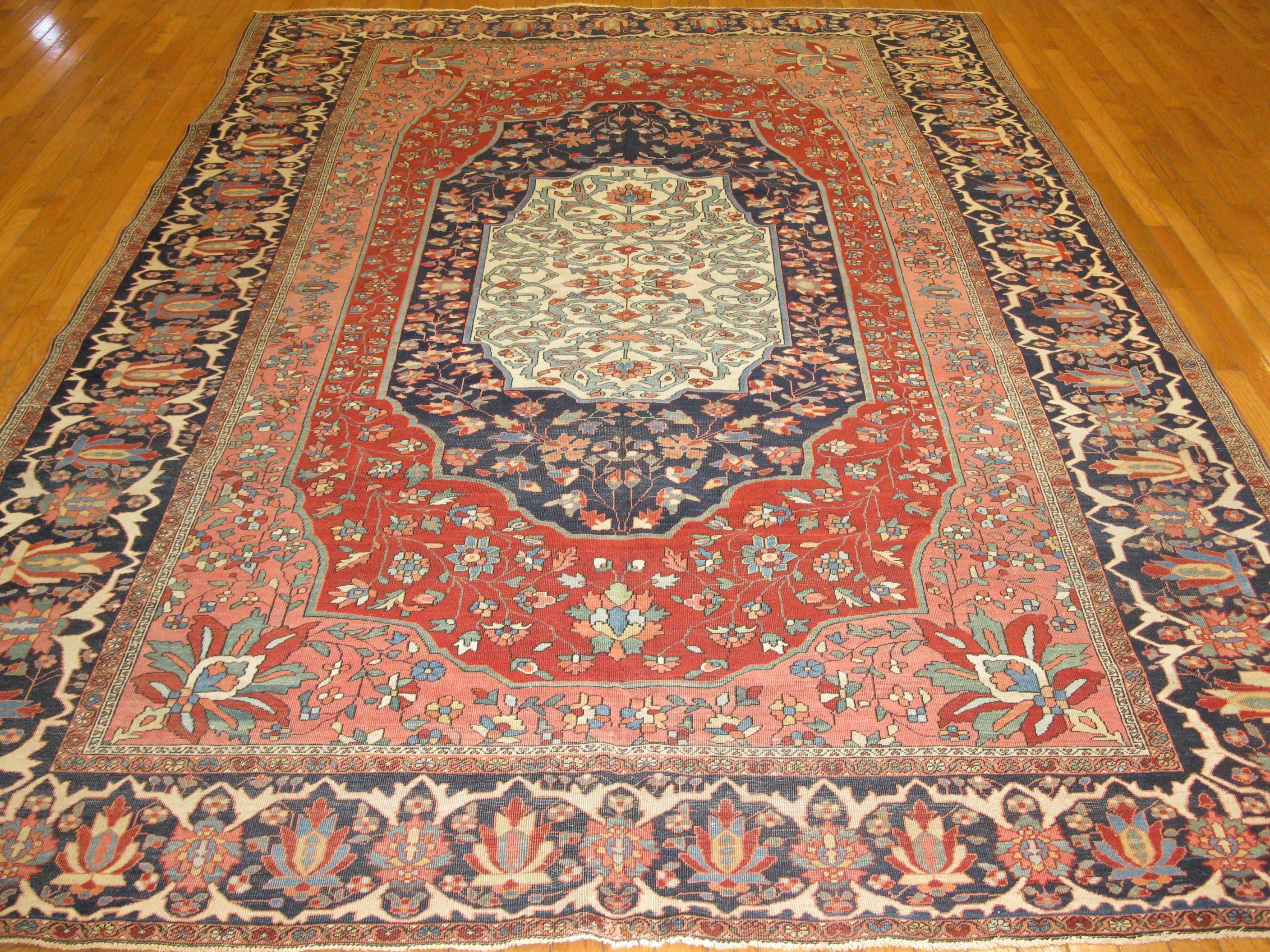 This is a finely knotted beautiful late 19th century antique Persian Sarouk Farahan. It has a distinct concentric three medallion design encased be a detailed nave blue color border. The rug measures 7' 1'' x 10' 2'' and is in great condition.