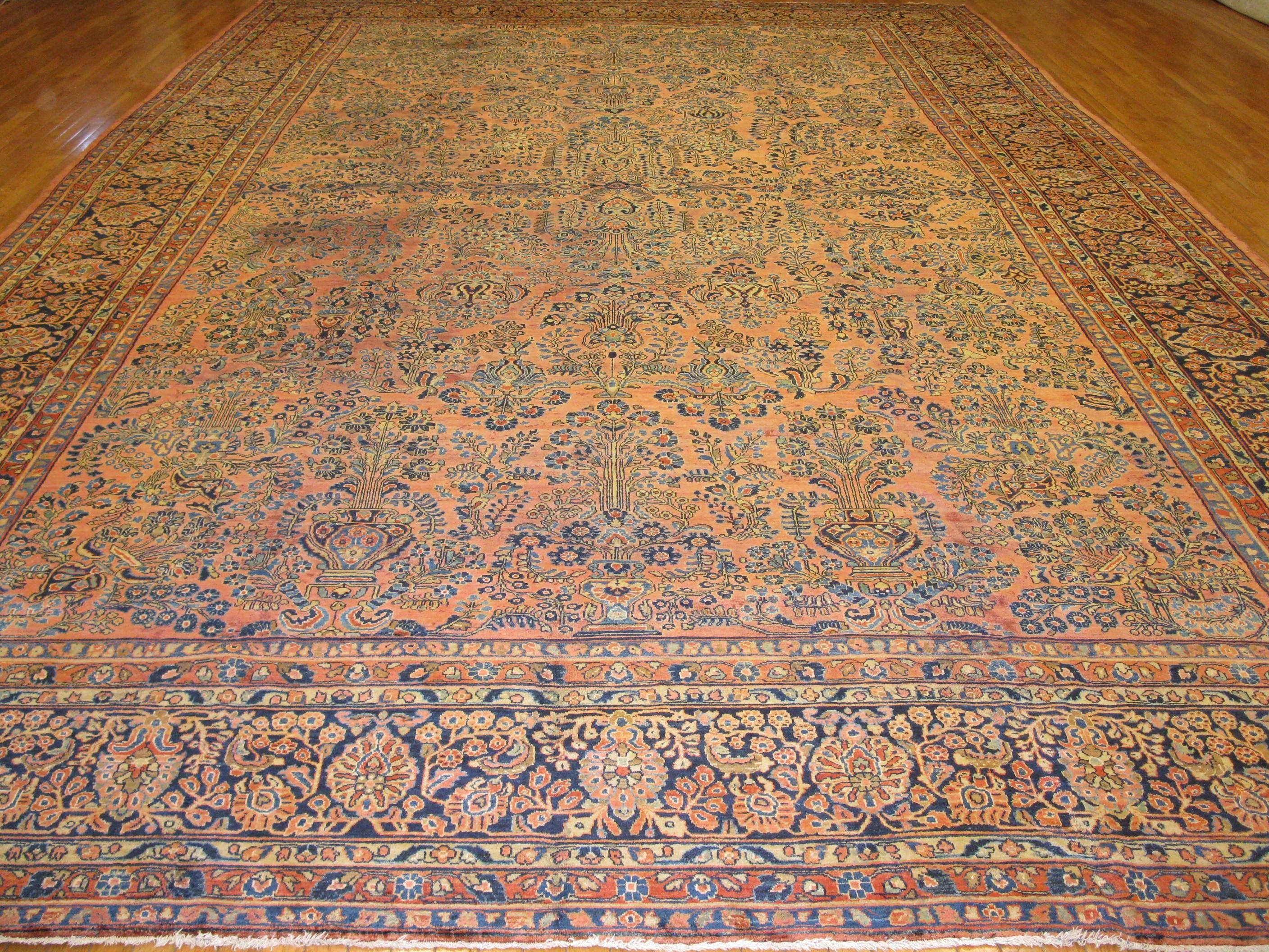 This is an elegant antique Persian Sarouk rug from Iran (Persian). The rug is the best example of the Sarouk rugs from around the turn of century with intricate all-over floral pattern on a copper color background. It measures 
12' 6