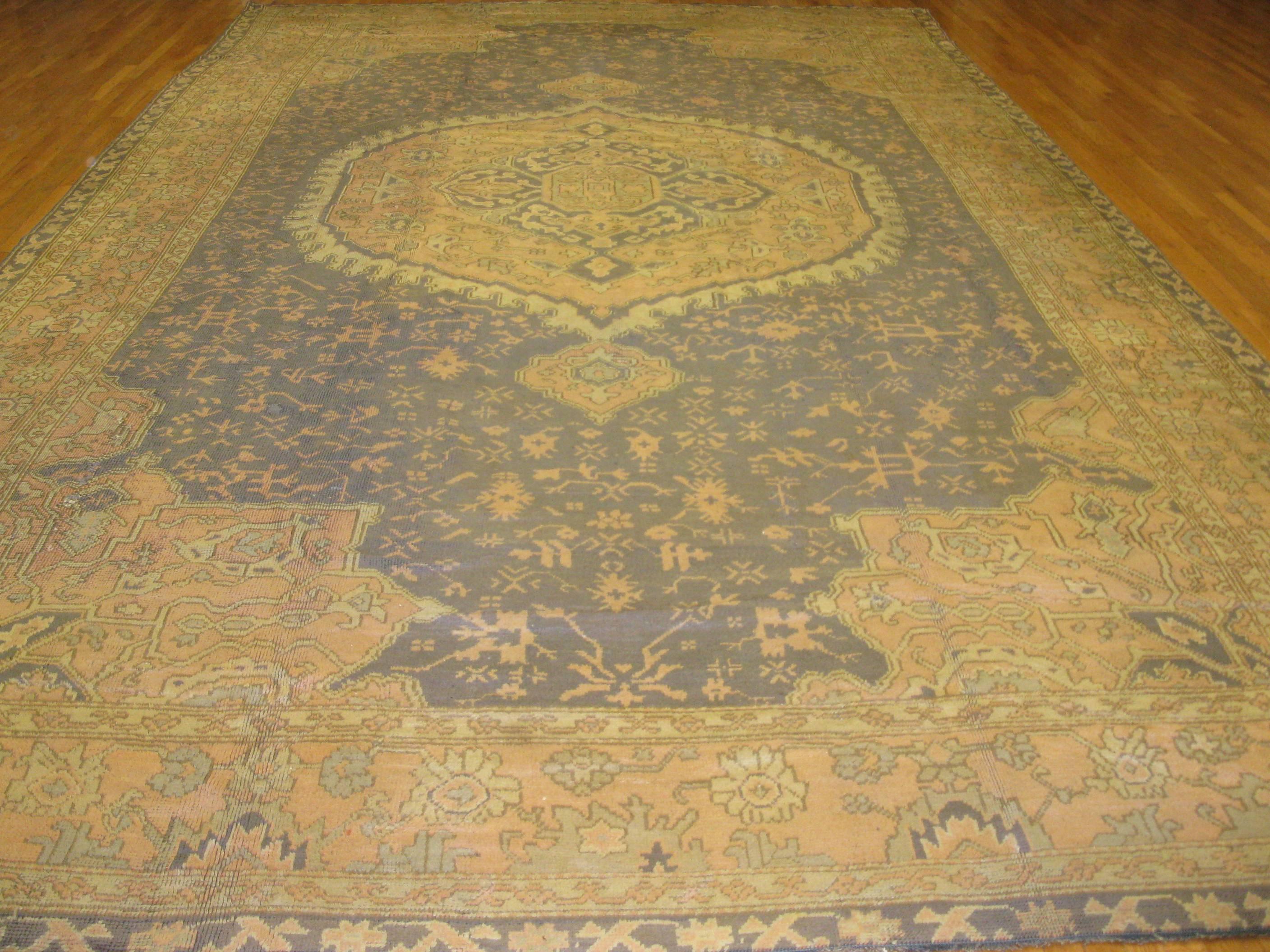 This is a beautiful hand-knotted antique Turkish Oushak rug. It has a very unique color combination which is result of antique wash. The rug measures 
11' 5