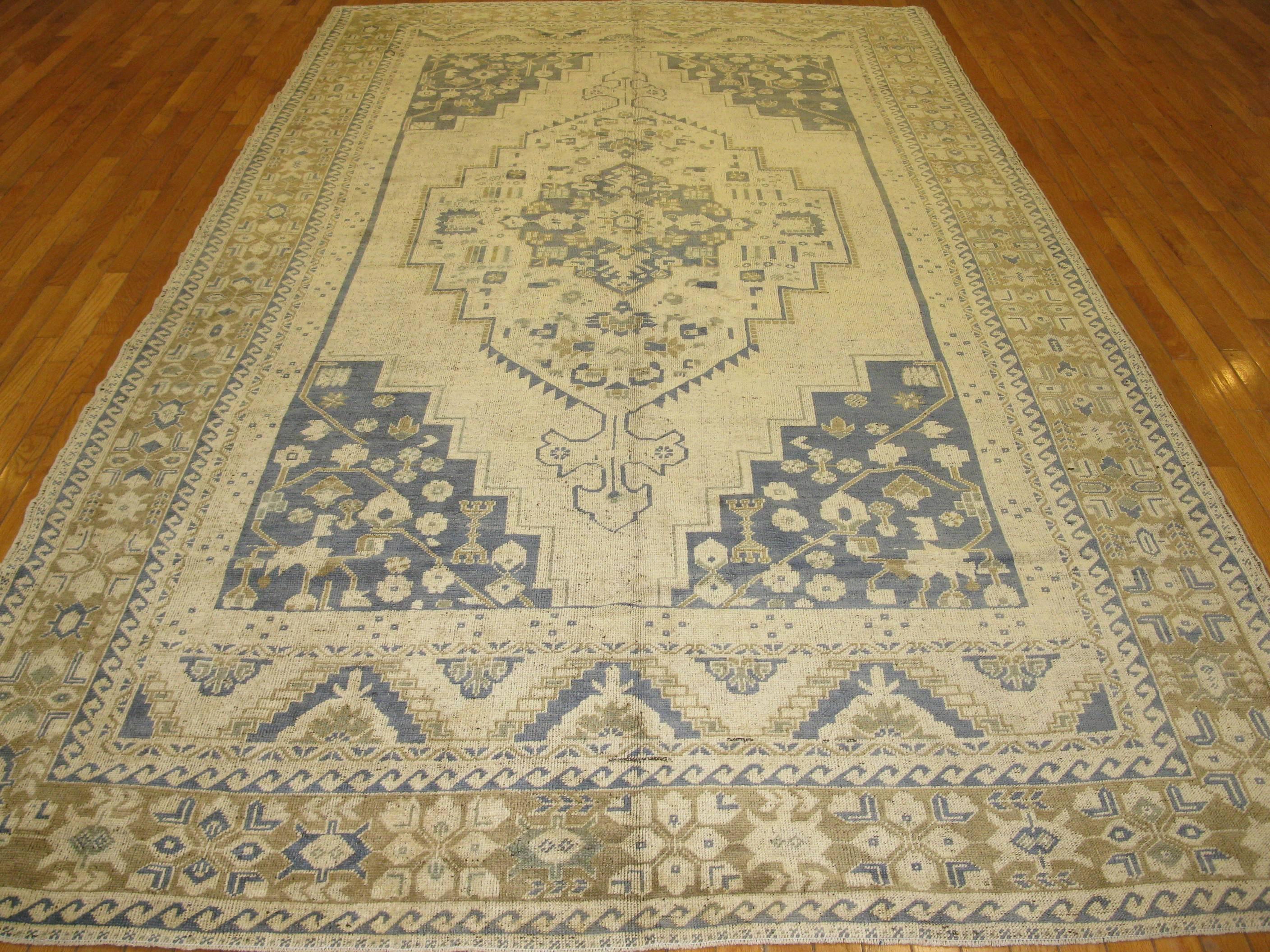 This is a vintage antique washed Turkish rug. It is hand knotted with 100% wool with an elegant geometric design. It measures 6' 8'' x 12' 2''.