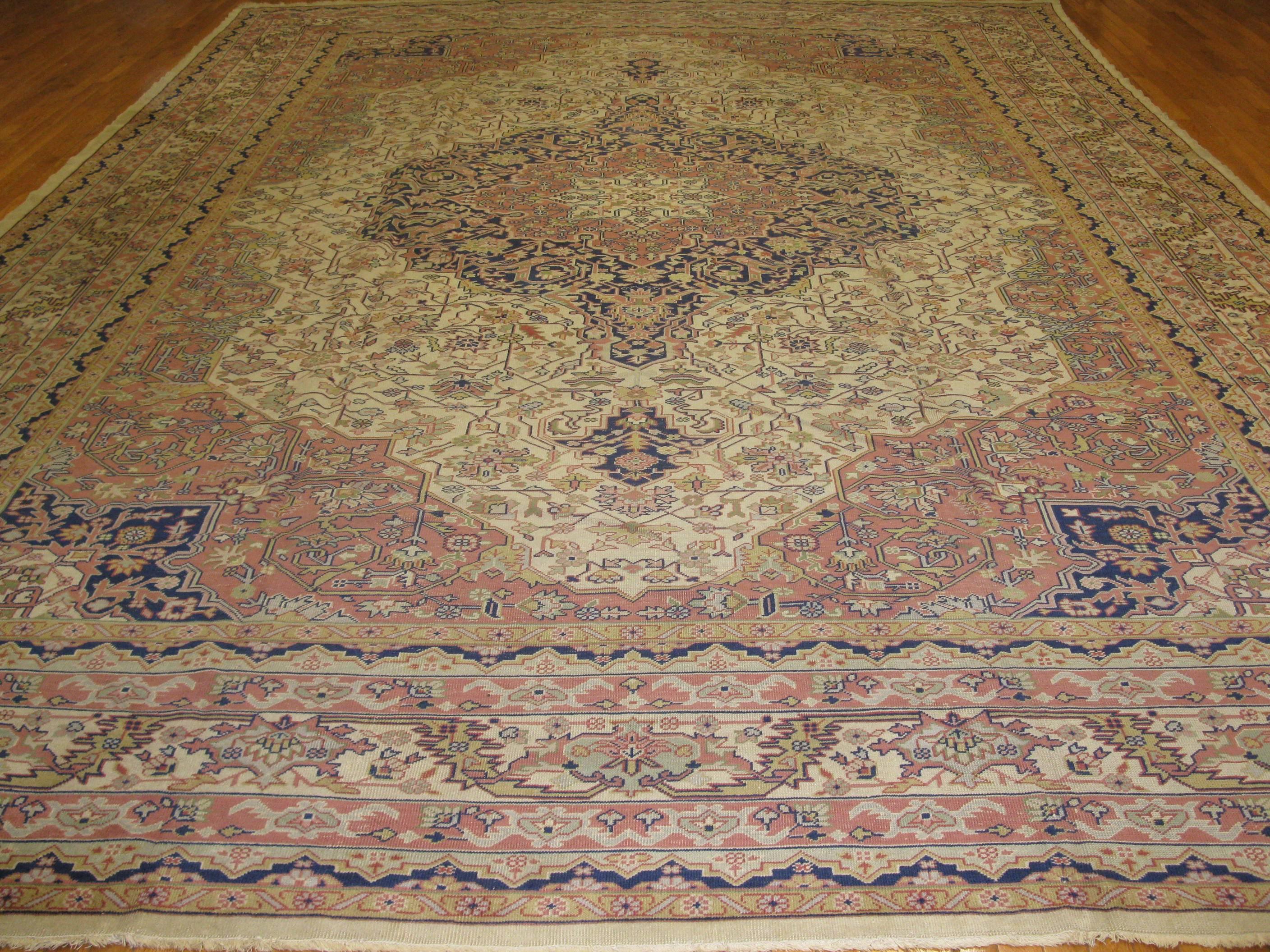 This is a beautiful antique hand knotted Turkish Sivas rug with a classic traditional floral design with a detailed pattern on an ivory color field. The rug measures 12' x 16' 10'' and in great condition.