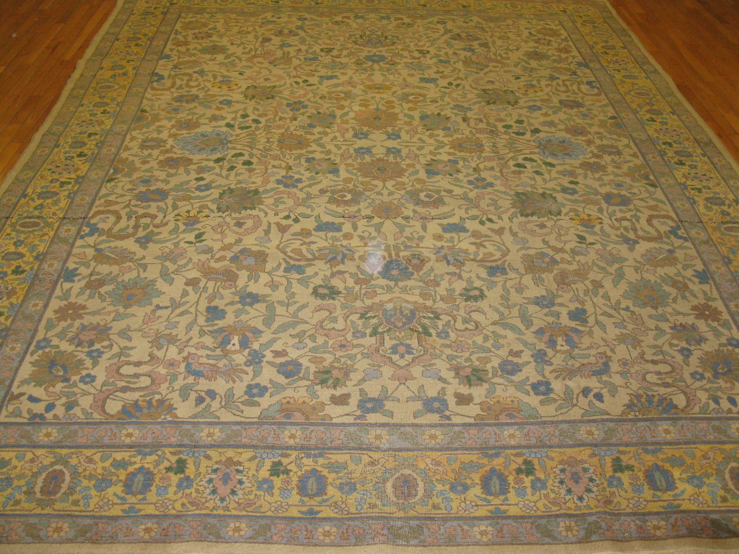 This is a beautiful antique hand-knotted Indian Agra rug. It has an elegant all-over detailed floral pattern on an ivory background and gold border. The rug measures 9' 2