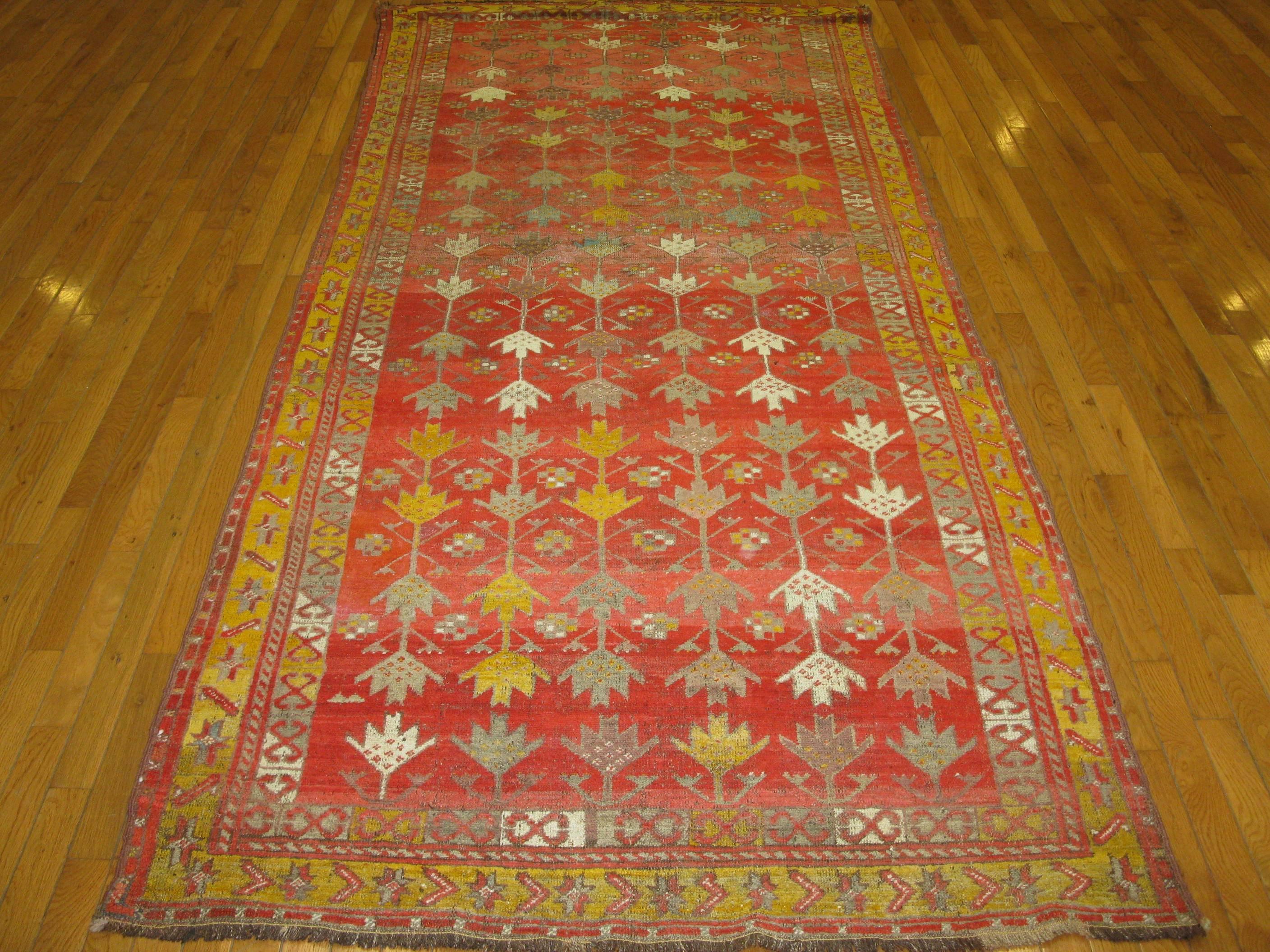 This is a beautiful hand-knotted antique Turkish Oushak rug with a unique all-over pattern on a coral red background. The rug measures 4' 4'' x 9' 10'' and is in great condition.