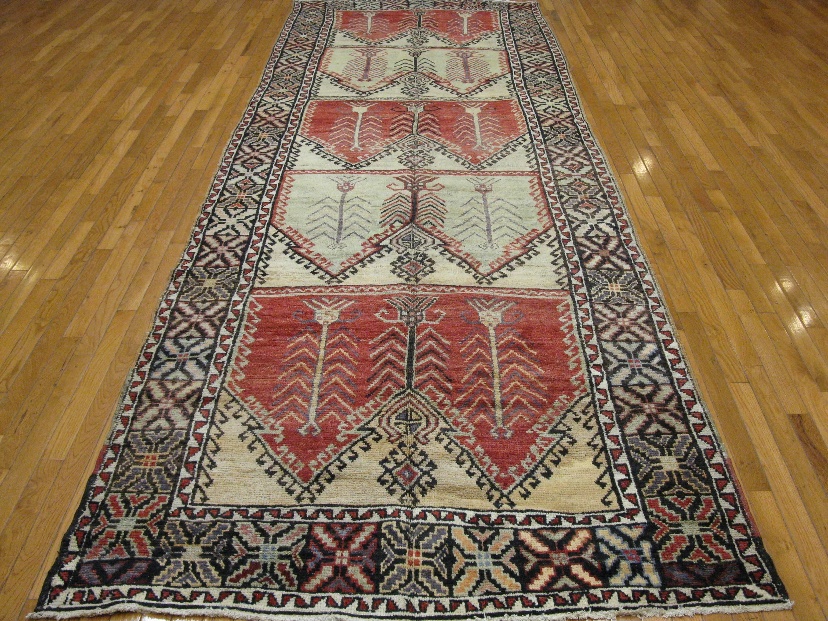 This vintage hand-knotted wool rug from Turkey would enhance any hallway.
Alternating red and ivory panels give the rug a unique look. The rug measures 4' 8'' x 14' and in very good condition.
       