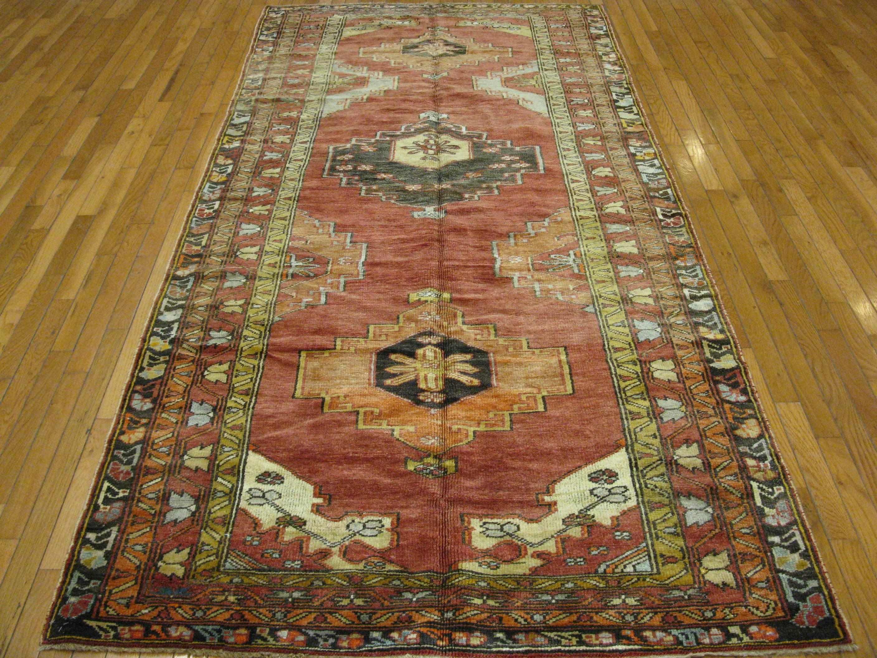 This is a vintage hand-knotted wide and long gallery runner from Turkey. It has a geometric tribal design made with wool pile and wool foundation. The rug measures 4' 7'' x 9' 9'' and it is in great condition.