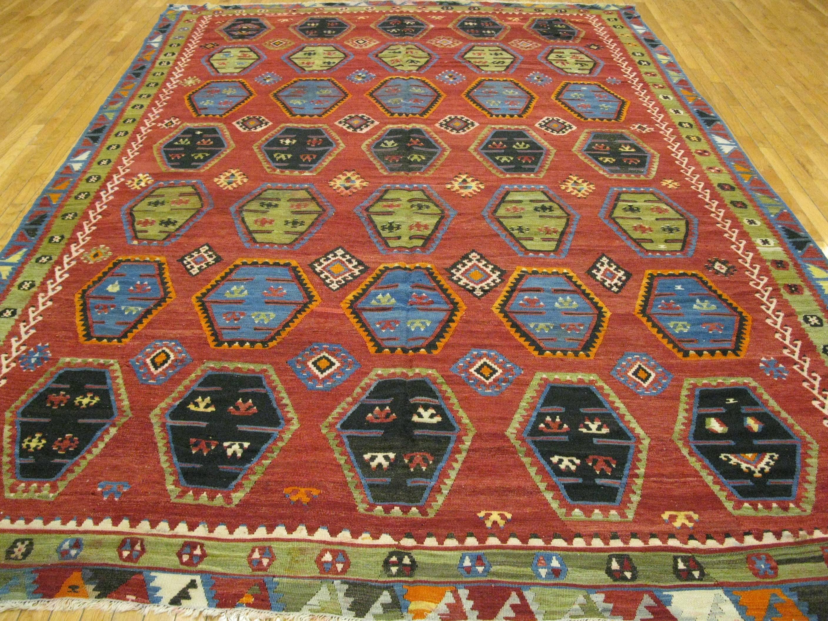 This is a beautiful vintage handwoven Caucasian Kazak design Kilim rug. The repetitive all-over medallions have created a balanced and easy design to work with. It is reversible and both sides of the rug can be used. It is made with all wool and