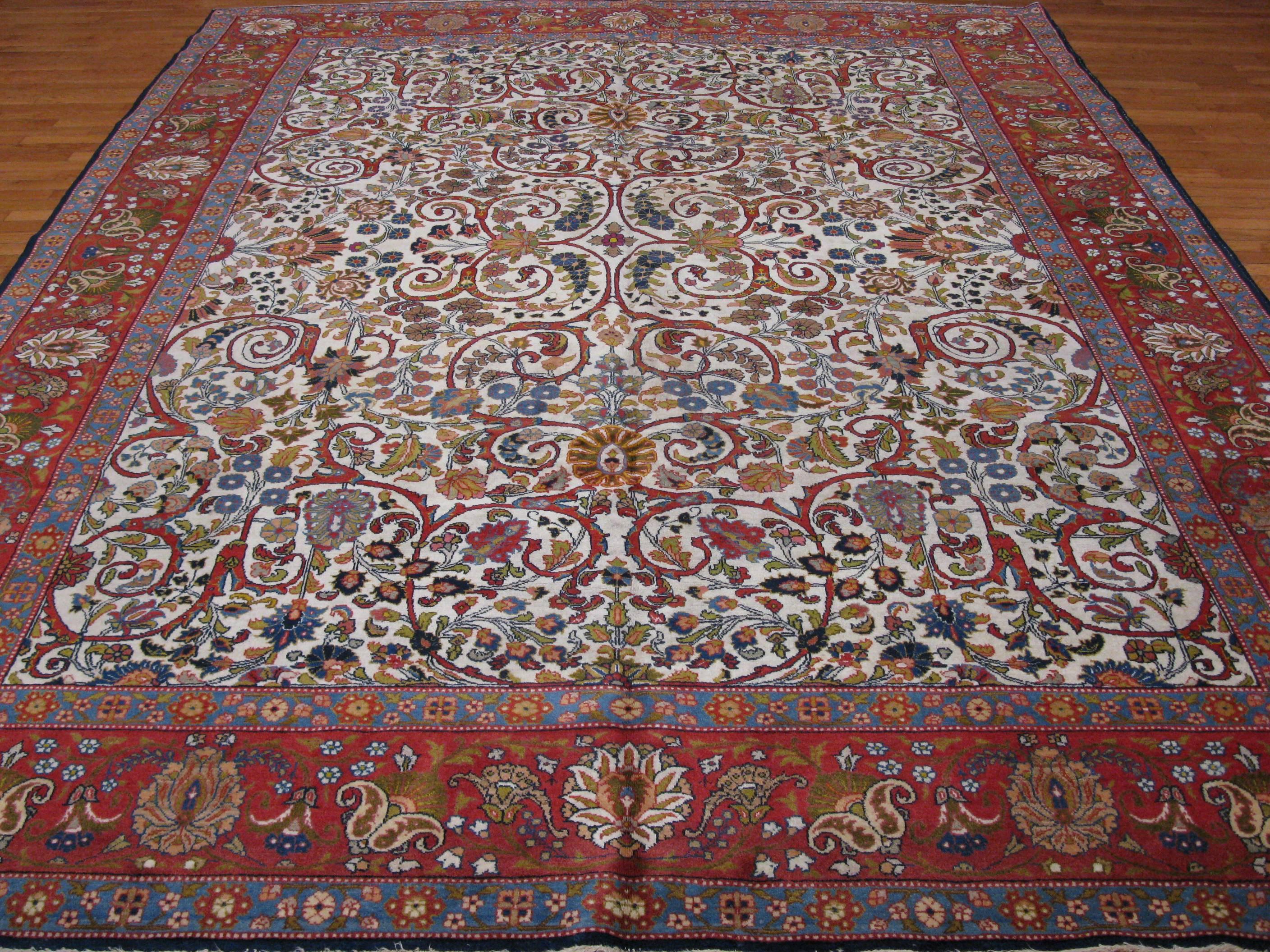 This is an elegant hand-knotted room size antique Persian Tabriz rug. It has a detailed floral pattern handmade with all natural dyed wool pile and cotton foundation. It measures 9' x 11' 8