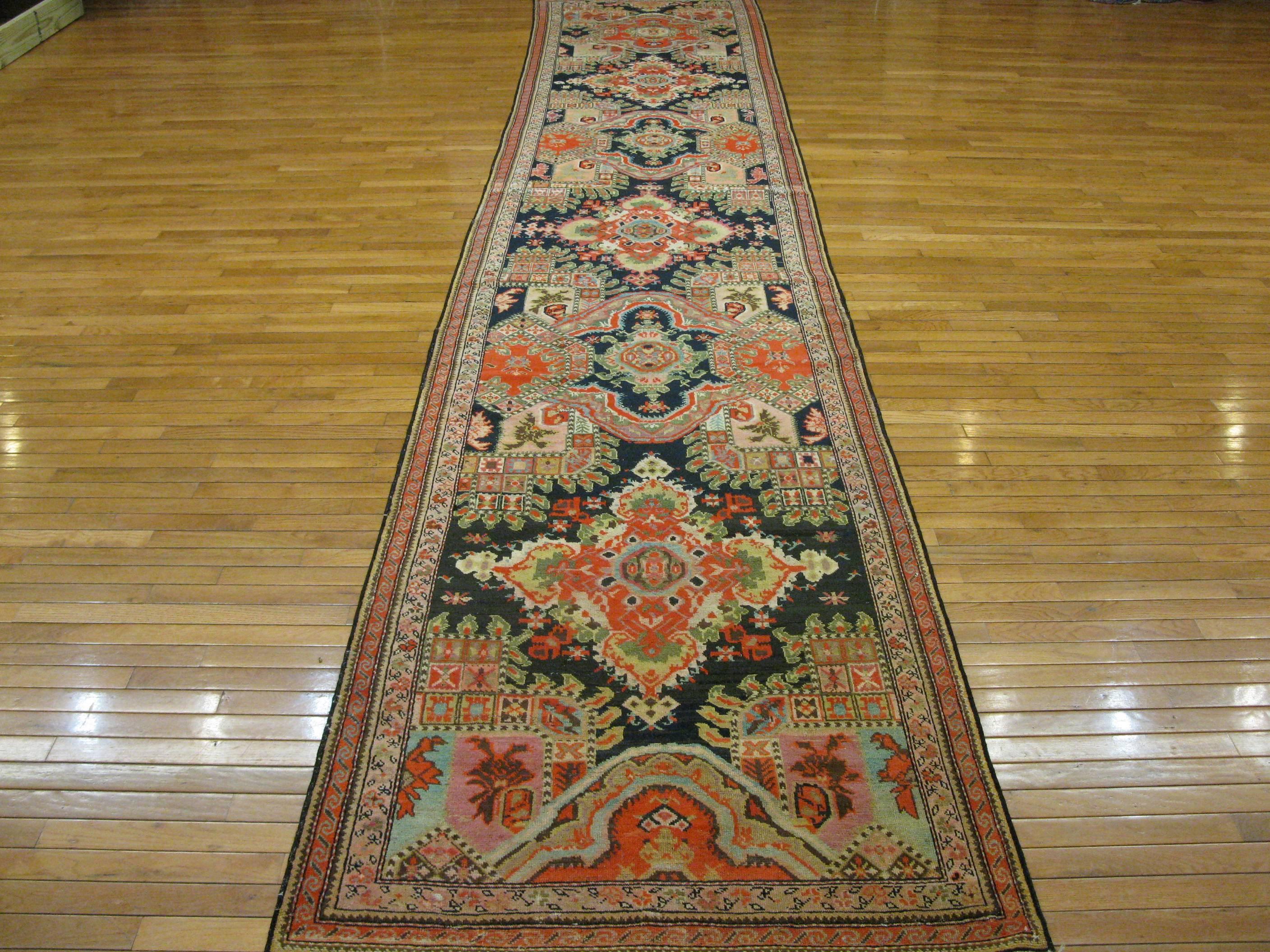 This is a beautiful hand-knotted long antique Caucasian Karabagh runner rug made with all wool and natural dyes in rich colors that would bring any hallway to life. It measures 3' 3