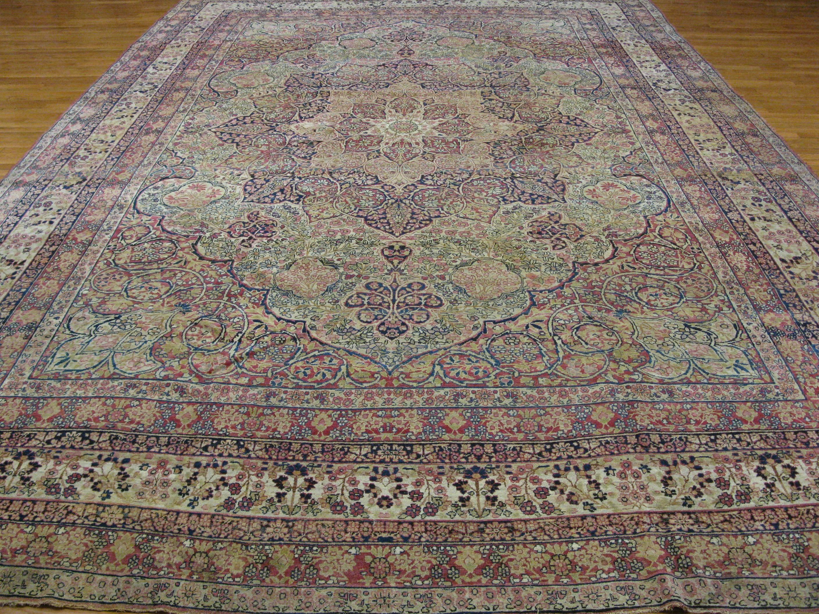 This is a beautiful large hand-knotted antique Persian Lavar Kerman. The rug has an intricate formal design made with all wool and natural dyes. The rug measures 10' 7'' x 16' 2''.