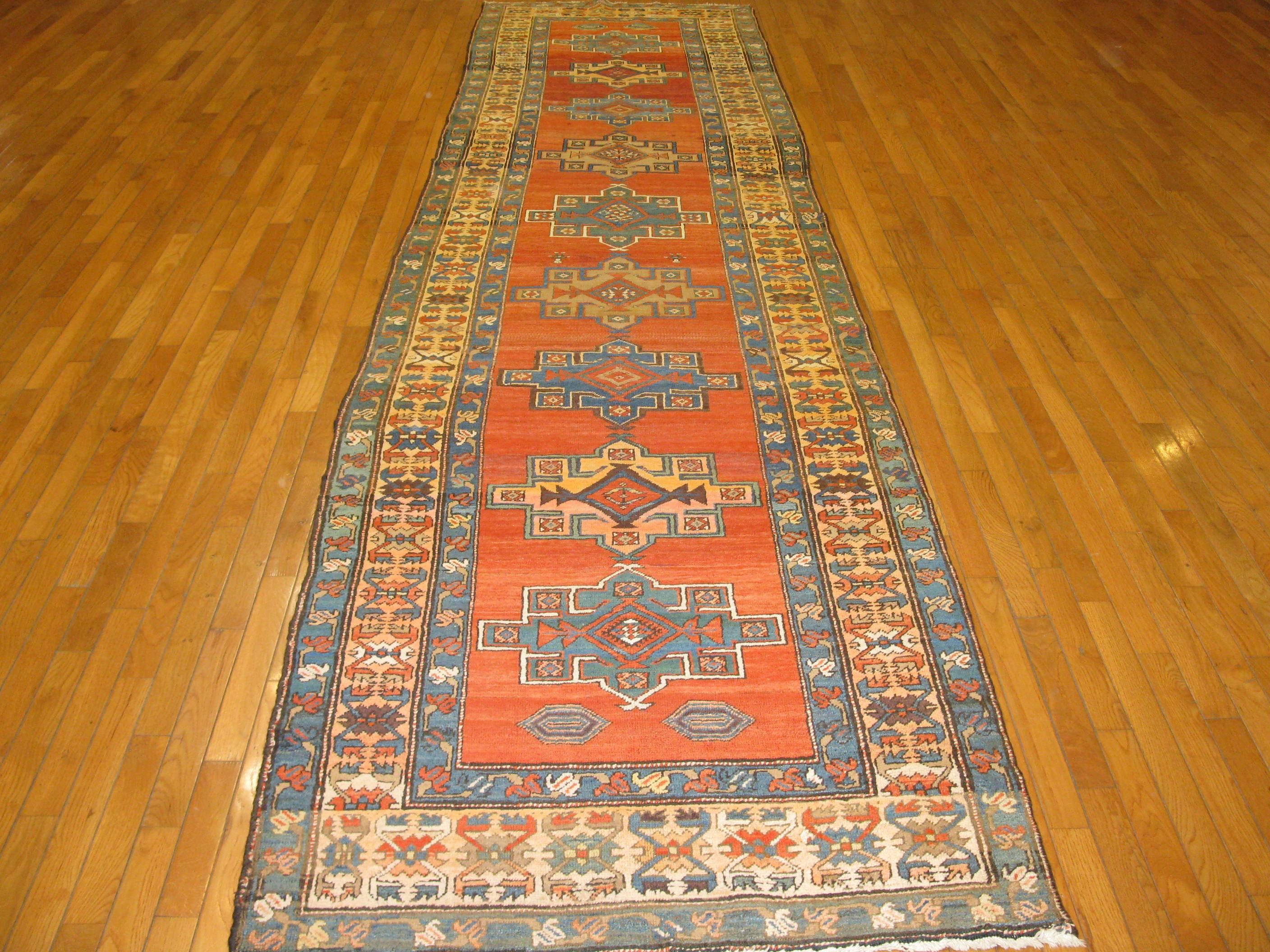 This is a beautiful and rare hand-knotted antique Persian Bakshaesh runne rug. The rug has a simple pattern usually a trademark of the bakshayesh rugs on a red color field. The rug measures 3'7'' x 14' and in very good condition.