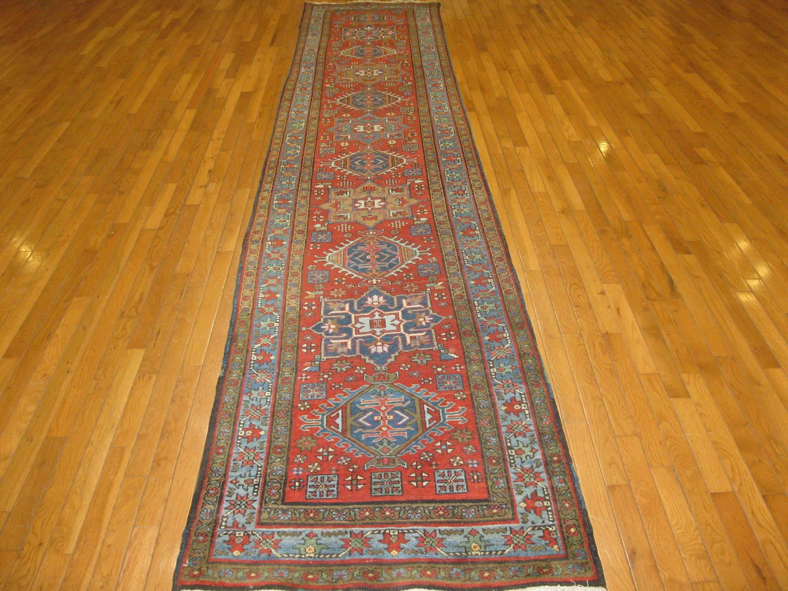 This is a beautiful antique hand-knotted Persian Heriz runner rug with multiple geometric medallion design on a red color field. The rug has a very fine weave and in excellent condition. It measures 2.10'' x 14.4''.